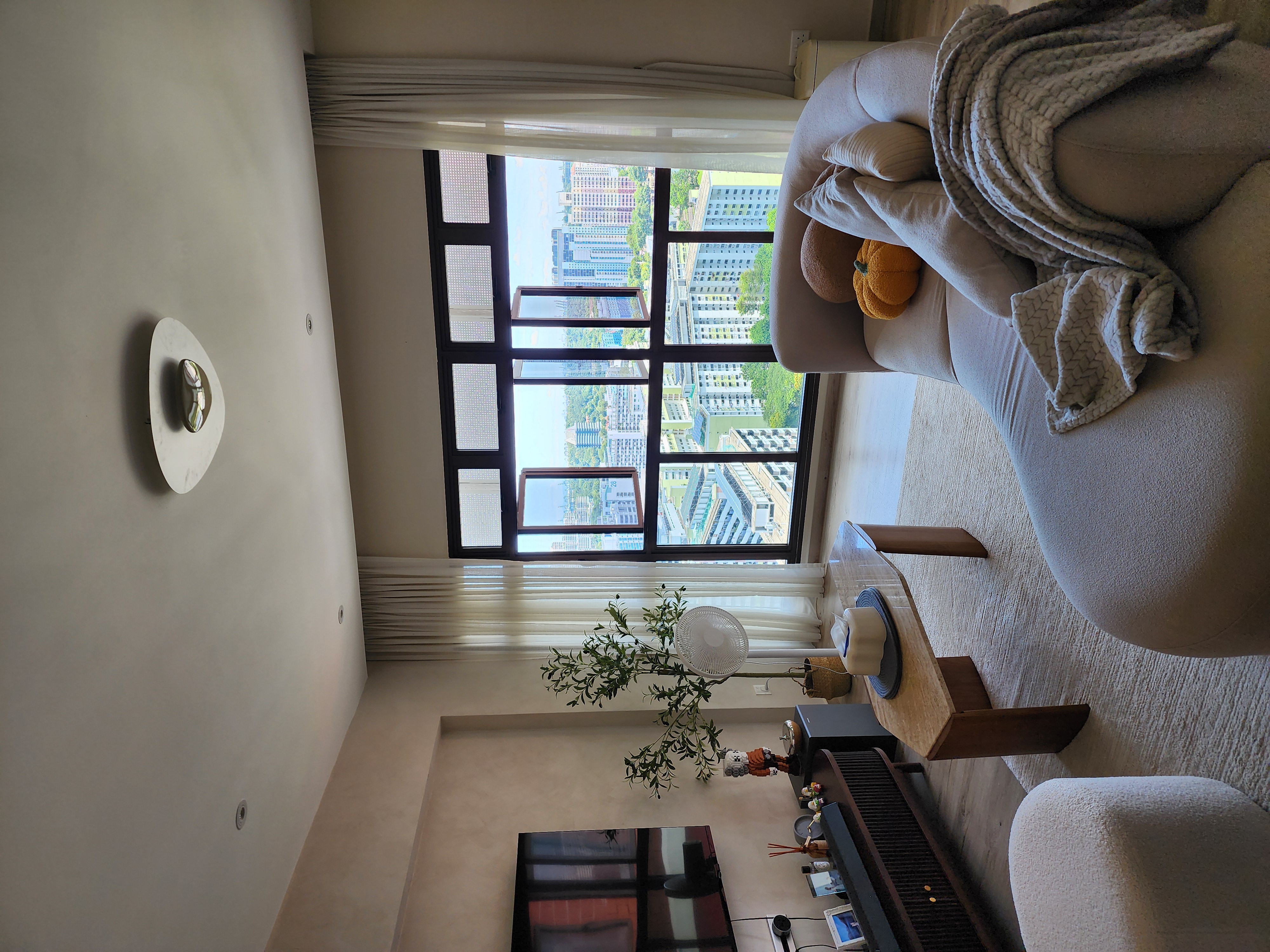 Inside our 1076sqft scandinavian neutral home - Large comfortable sofa, beige cushions, plush blanket, modern ceiling light