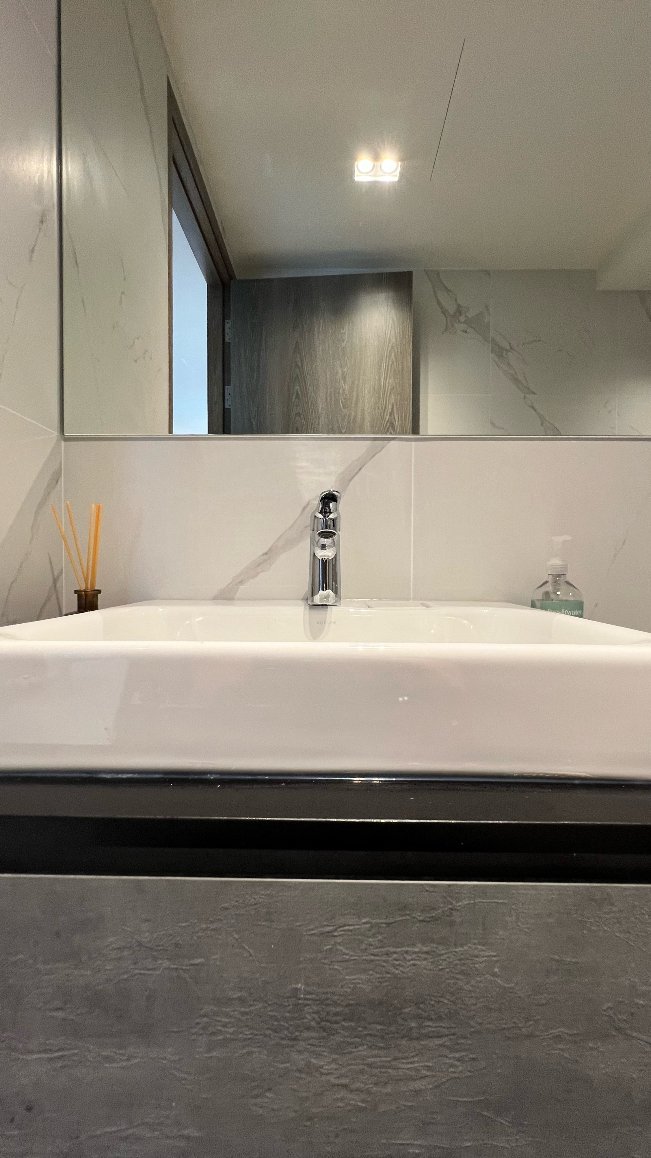 Our little cosmopolitan treehouse! - White modern bathroom sink, sleek faucet, minimalist design, marble backsplash, wooden