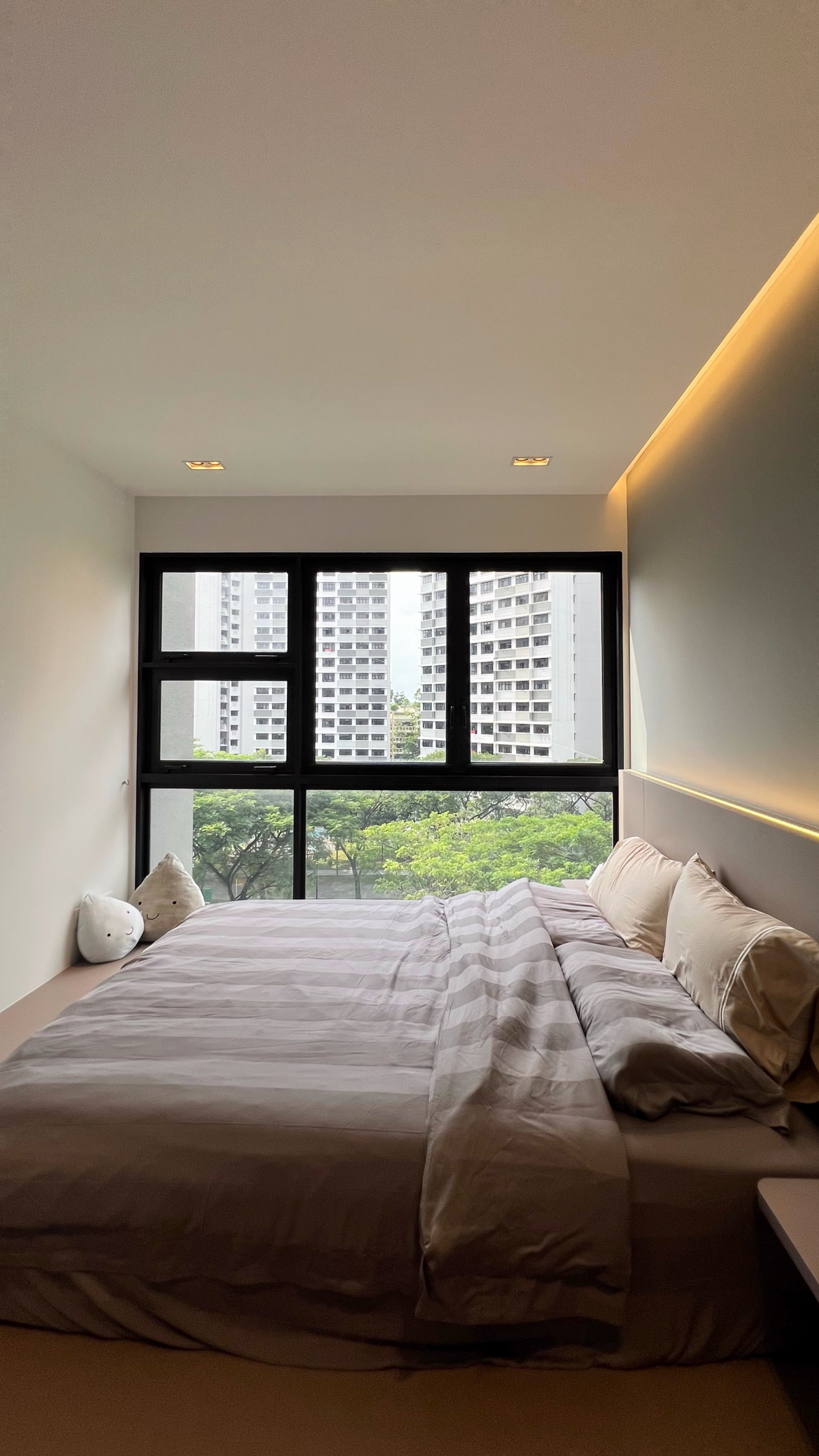 Our little cosmopolitan treehouse! - Modern bedroom with large windows, neutral color palette, plush pillows, soft lighting