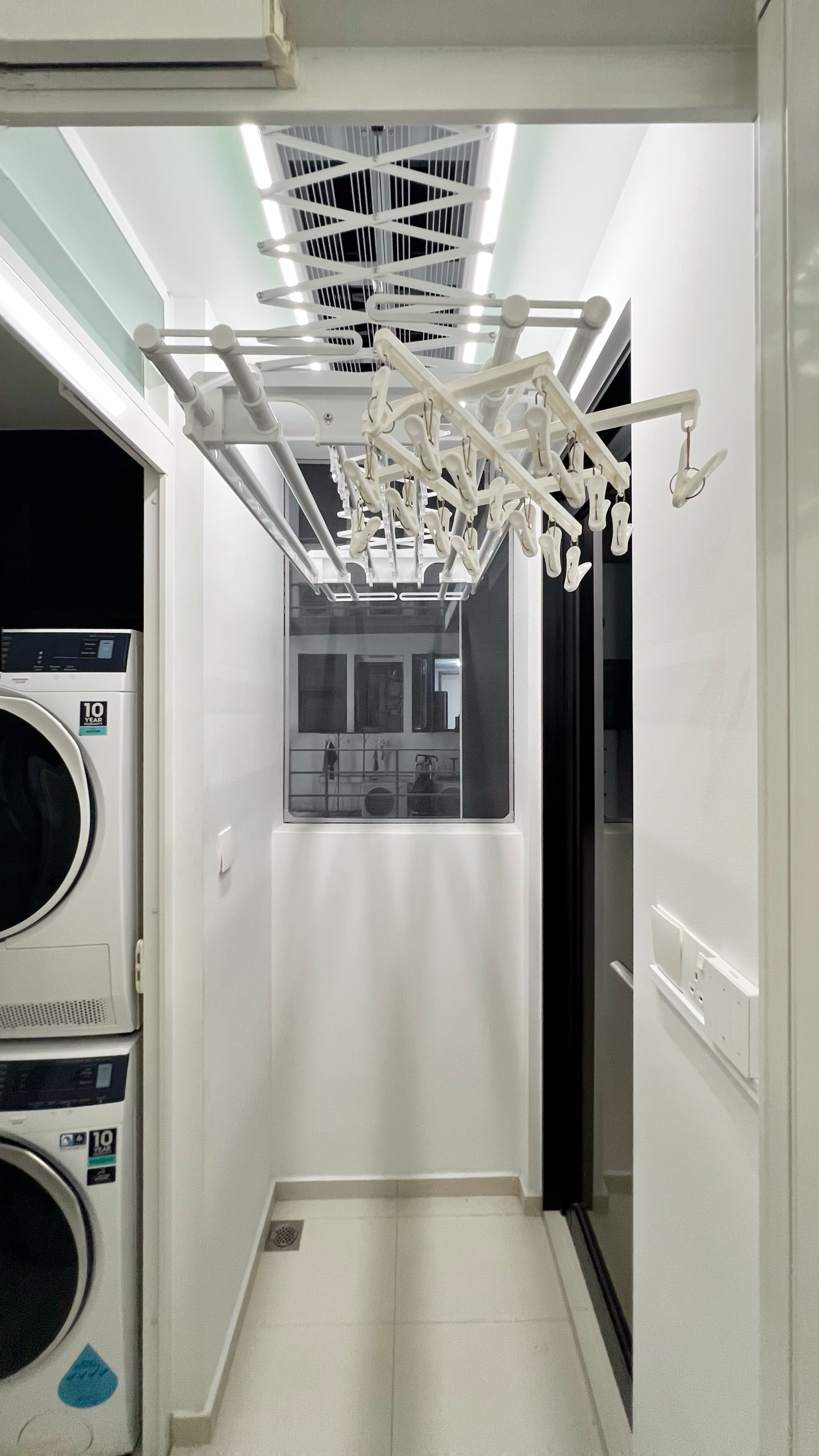 Our little cosmopolitan treehouse! - Modern laundry room with sleek white appliances, White laundry hangers hanging from a
