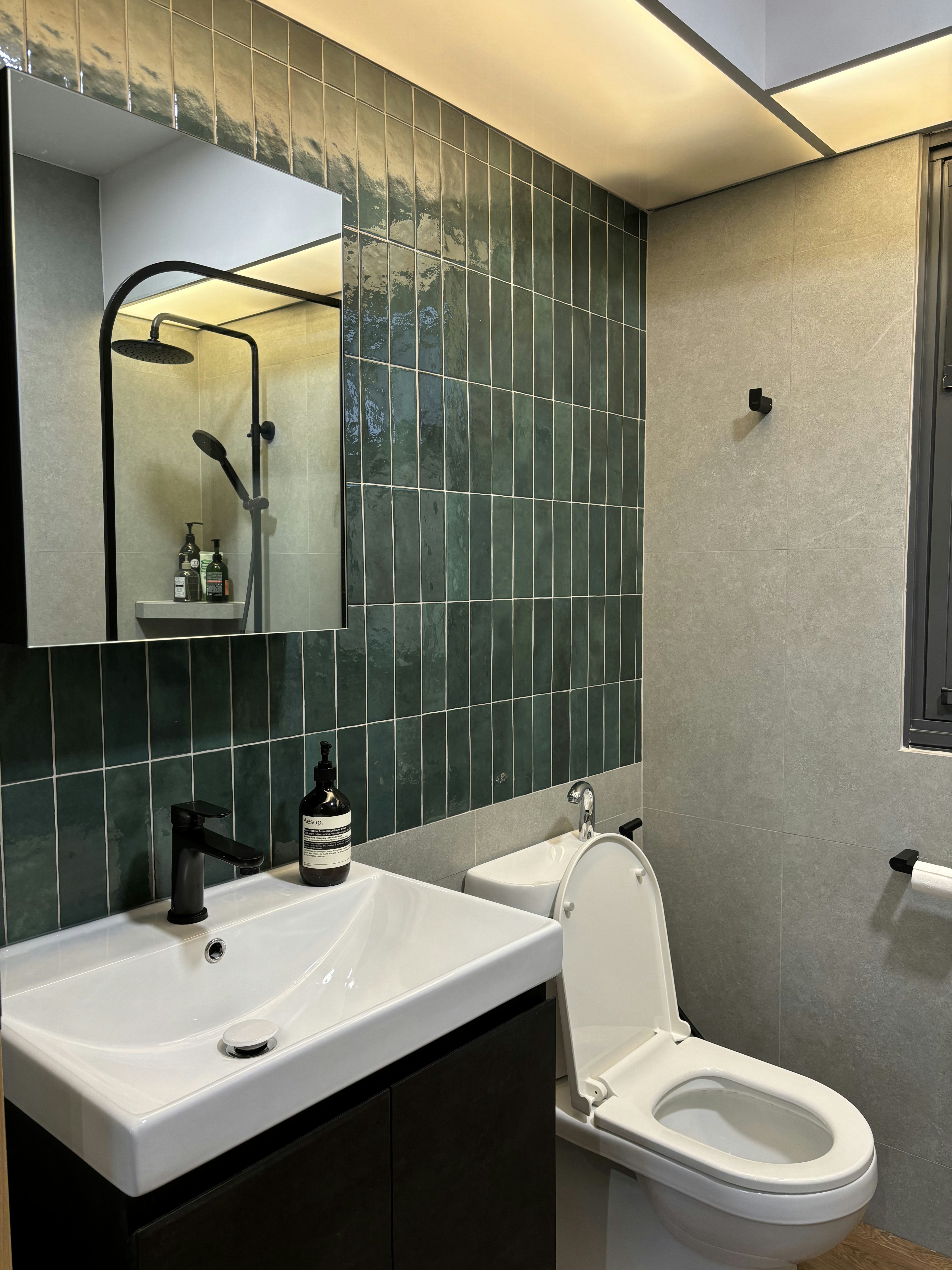 Inside a practical Modern Mediterranean 4RM BTO - Modern bathroom with green tiled walls, sleek black faucet, white sink with