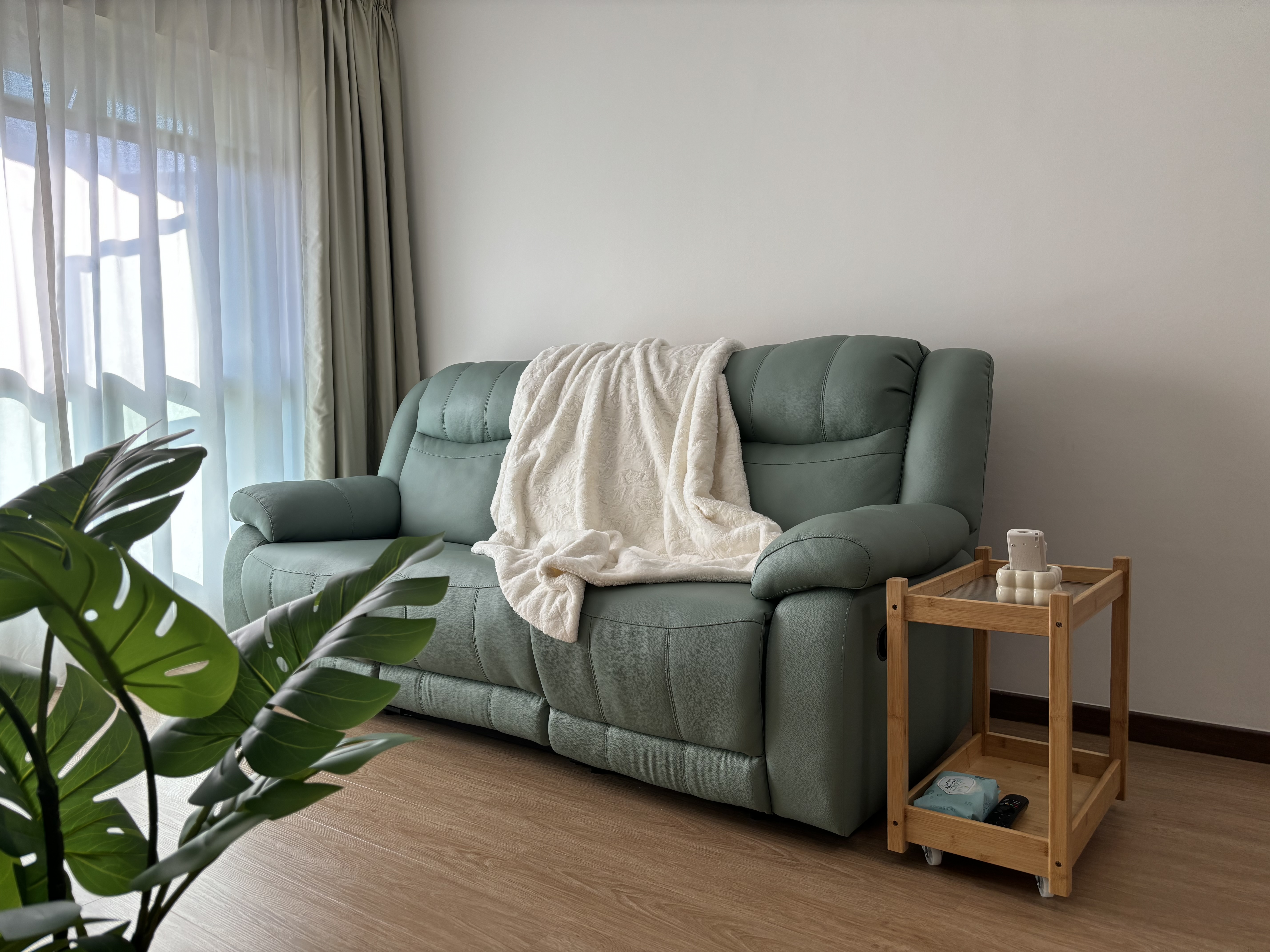 Bright, Airy & Relaxing 4-room Coastal Farmhouse at $40k - Green leather sofa, white blanket, wooden side table, indoor