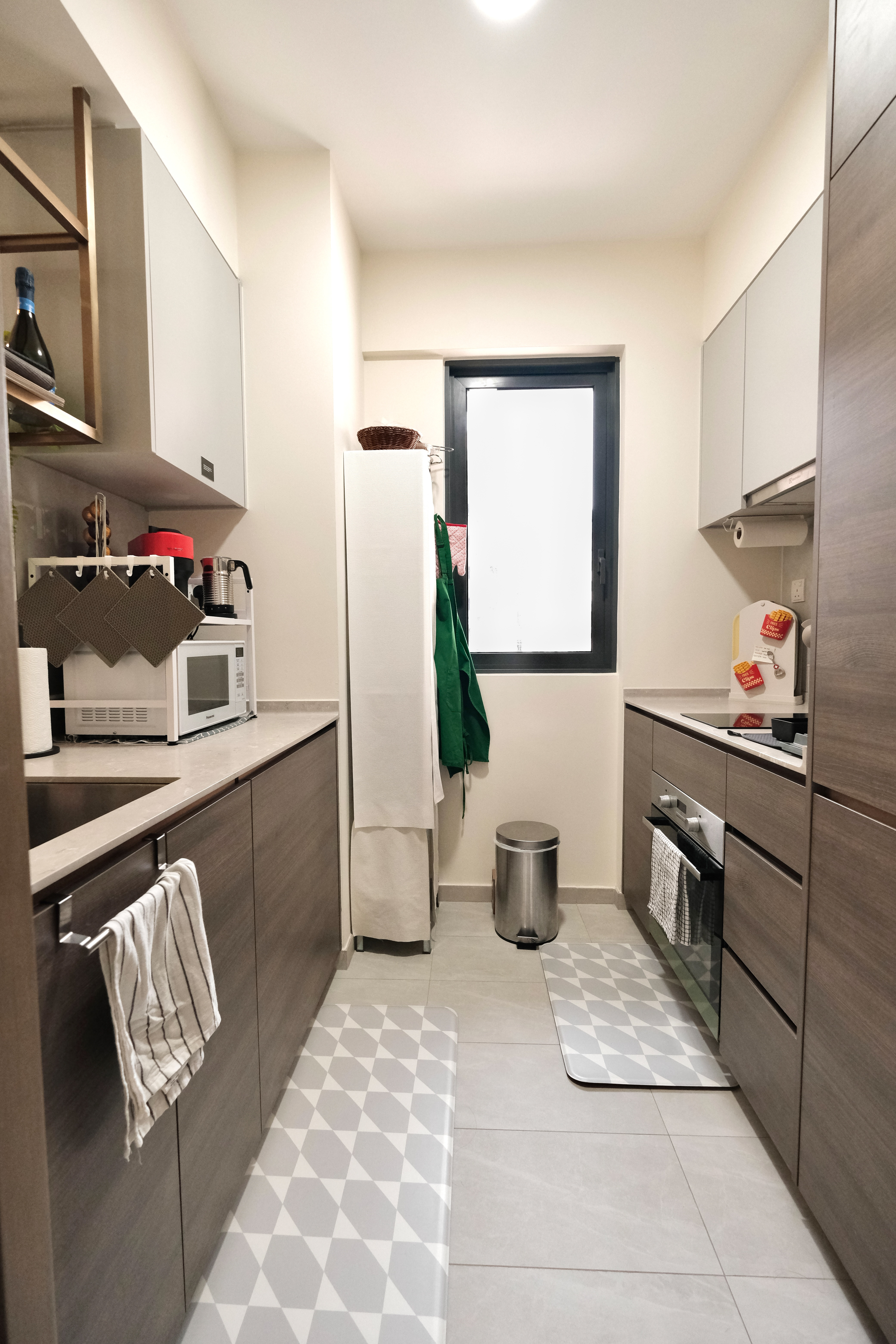 Minimalist Cozy Living in the North-East - Modern kitchen with integrated appliances, white cabinets, gray countertops