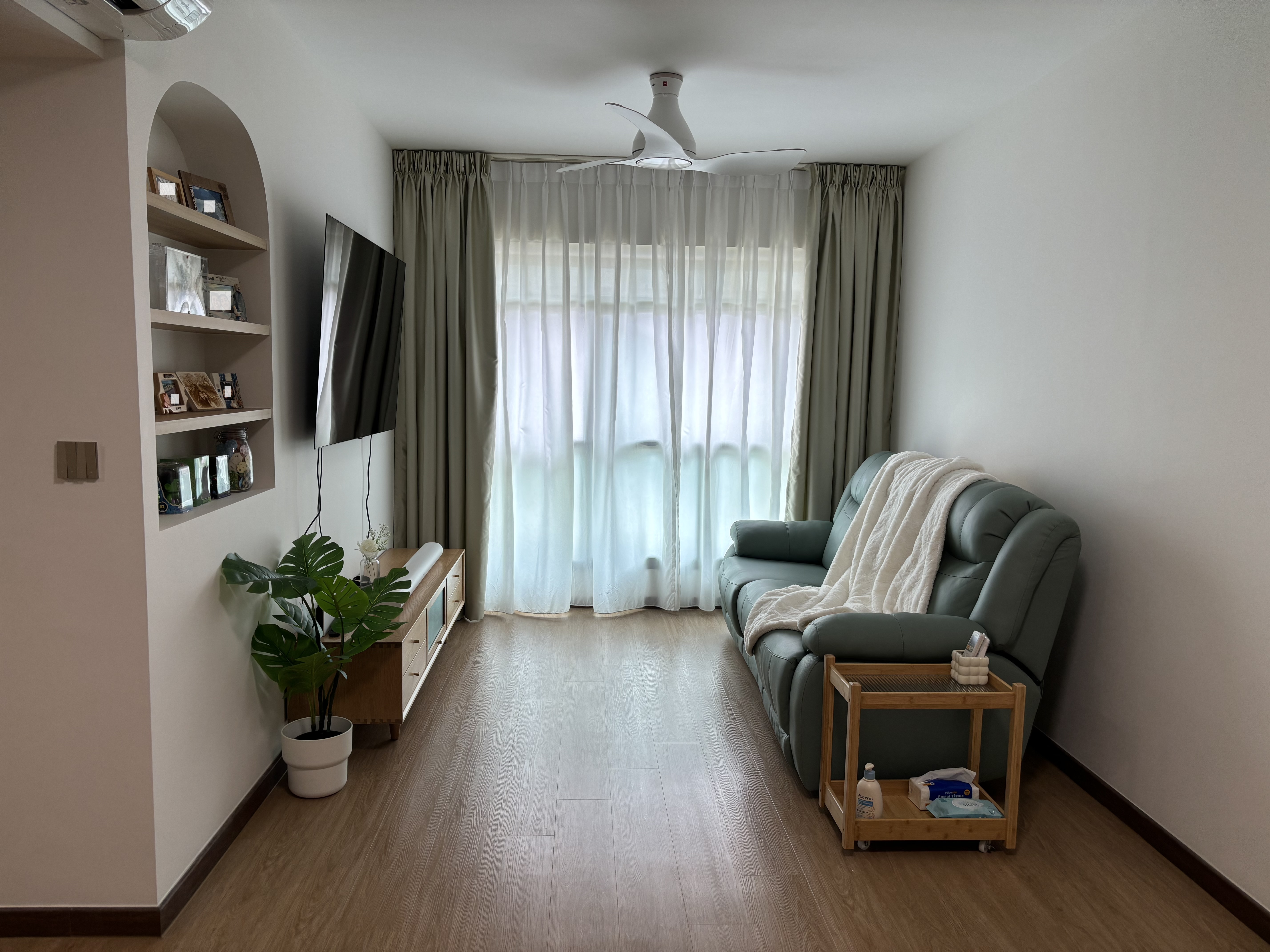 Bright, Airy & Relaxing 4-room Coastal Farmhouse at $40k - Modern living room with green sofa, white blanket, wooden floor