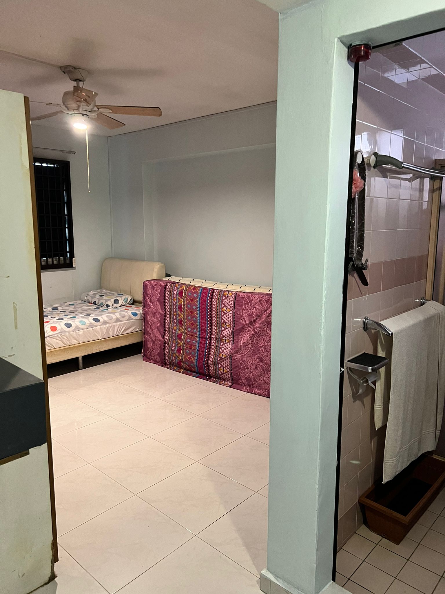Transforming a 92' flat for 2 92's 🙉🙊 - Twin bed with colorful bedspread, beige headboard, ceiling fan, tiled floor, light