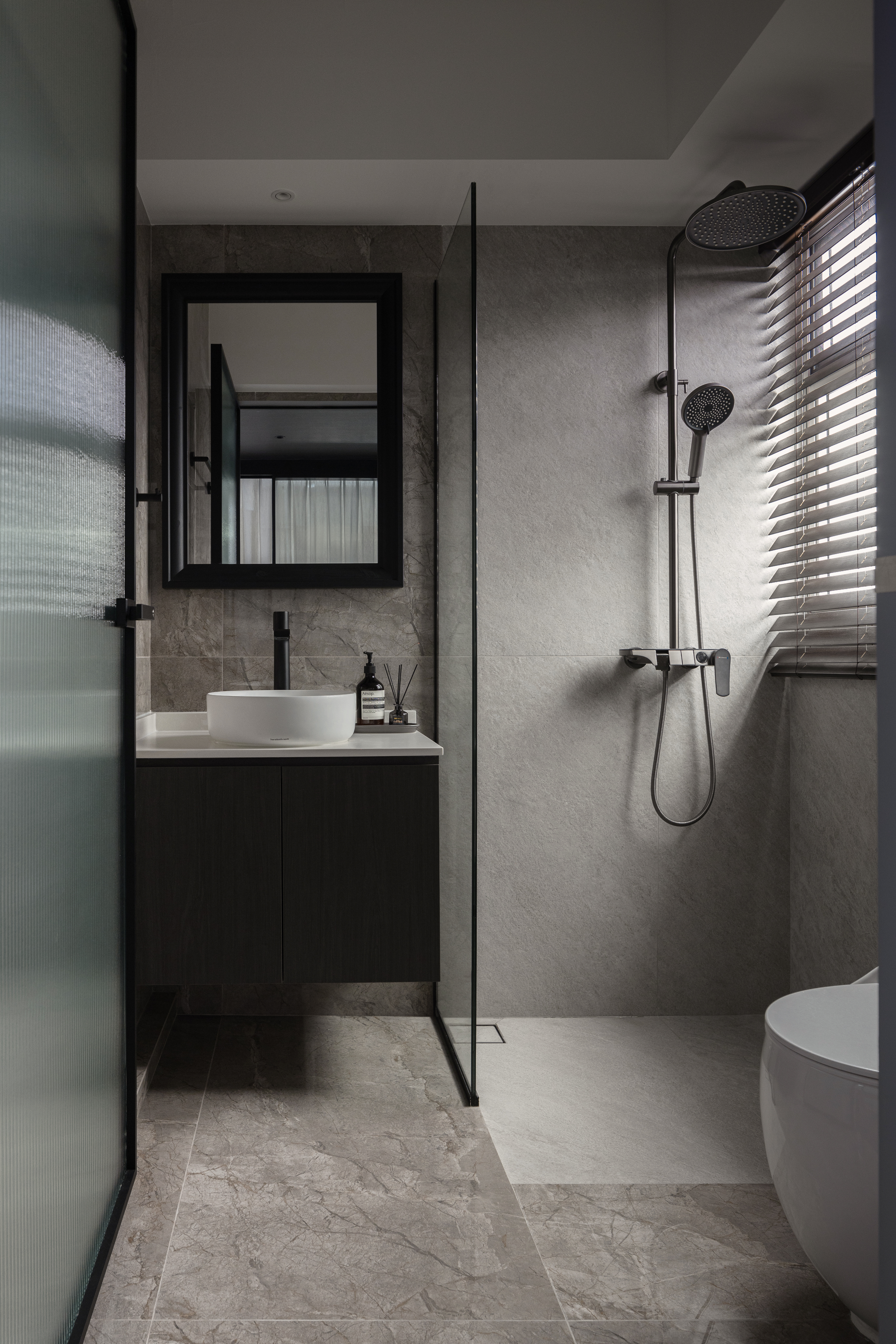 Inside The $70K Reno Of A Dark Minimalist Luxury 5-Room HDB Flat - Modern bathroom with sleek design, gray marble tiles