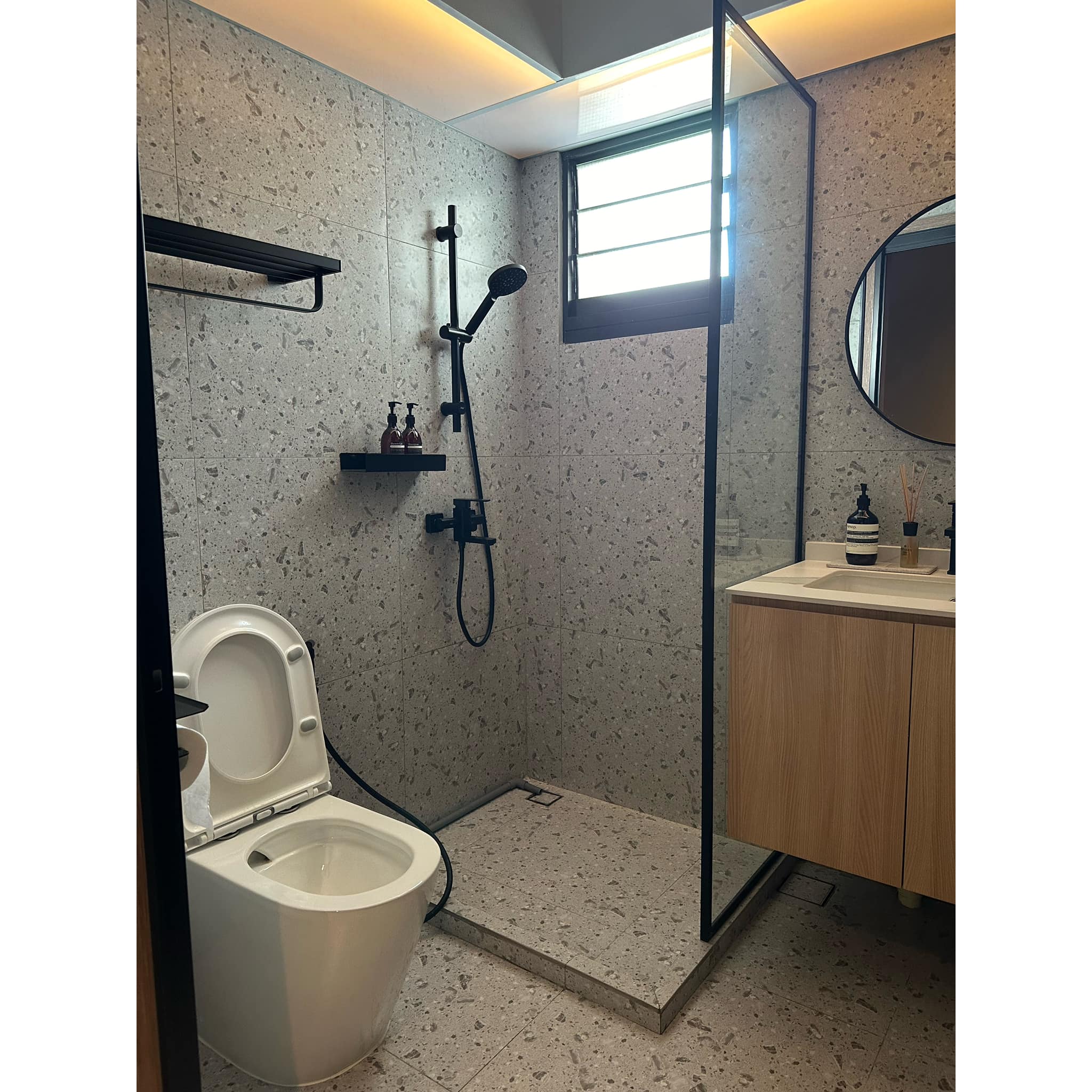 Transforming A 4-room BTO Into A $90k Modern-luxe HDB Hotel  - Modern bathroom with speckled tiles, white toilet, black