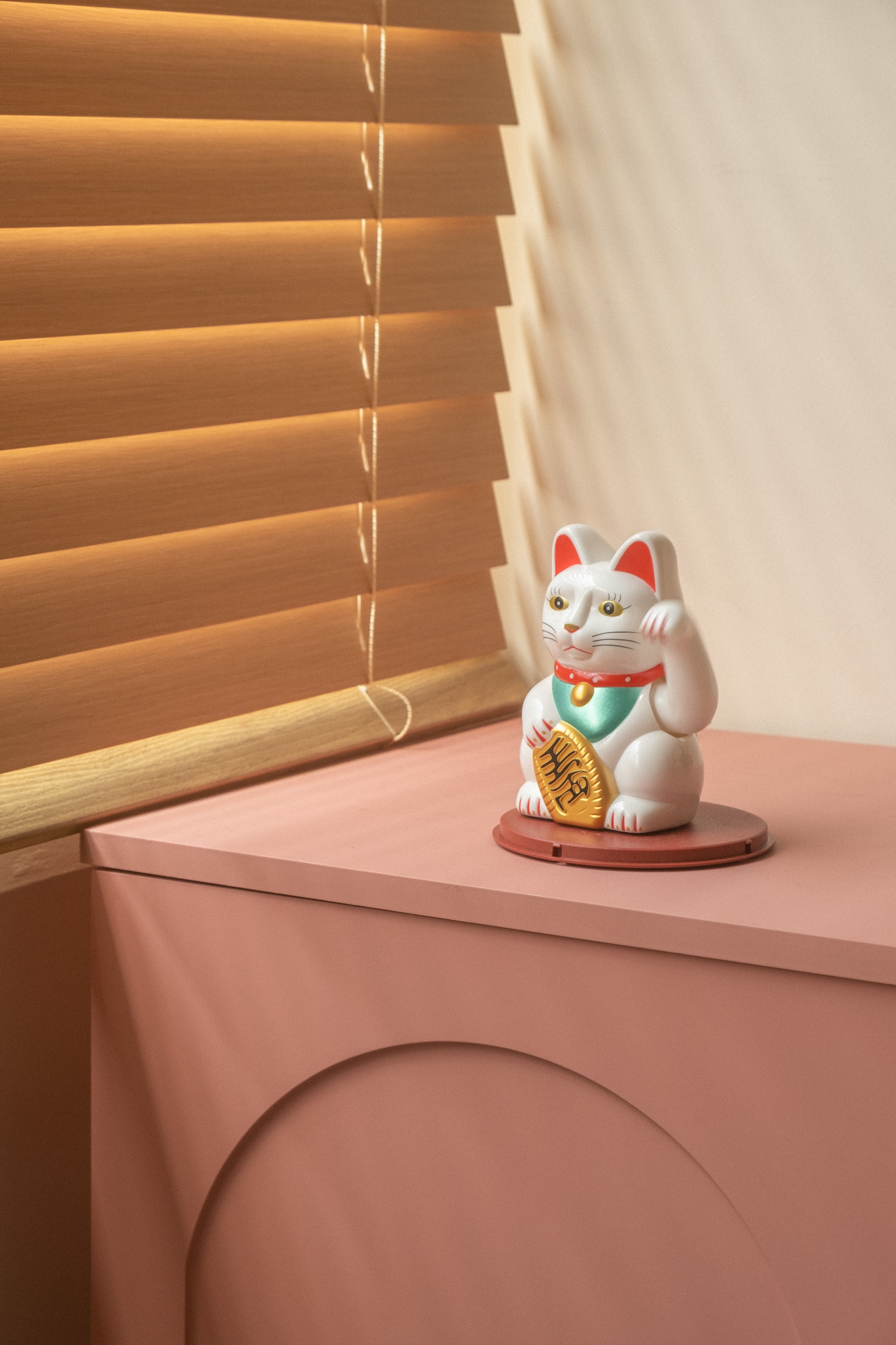 Maximising space in our cosy & quirky home with cats - Wooden blinds casting shadows, white cat figurine with red collar