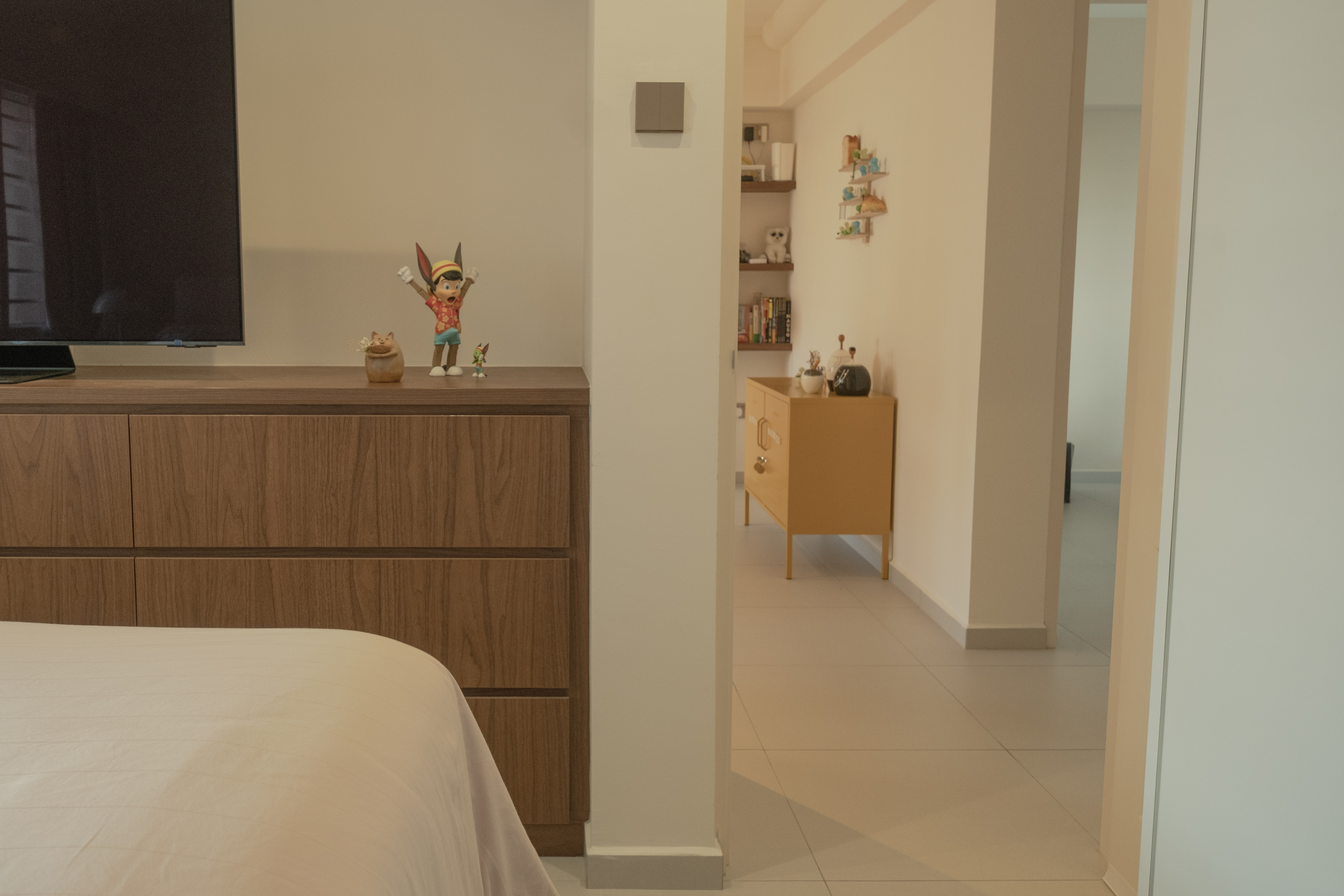 Inside our odd-shaped mid-century eclectic home - Wooden dresser, TV on top, figurine, cat, small figurine, toy, bookshelf