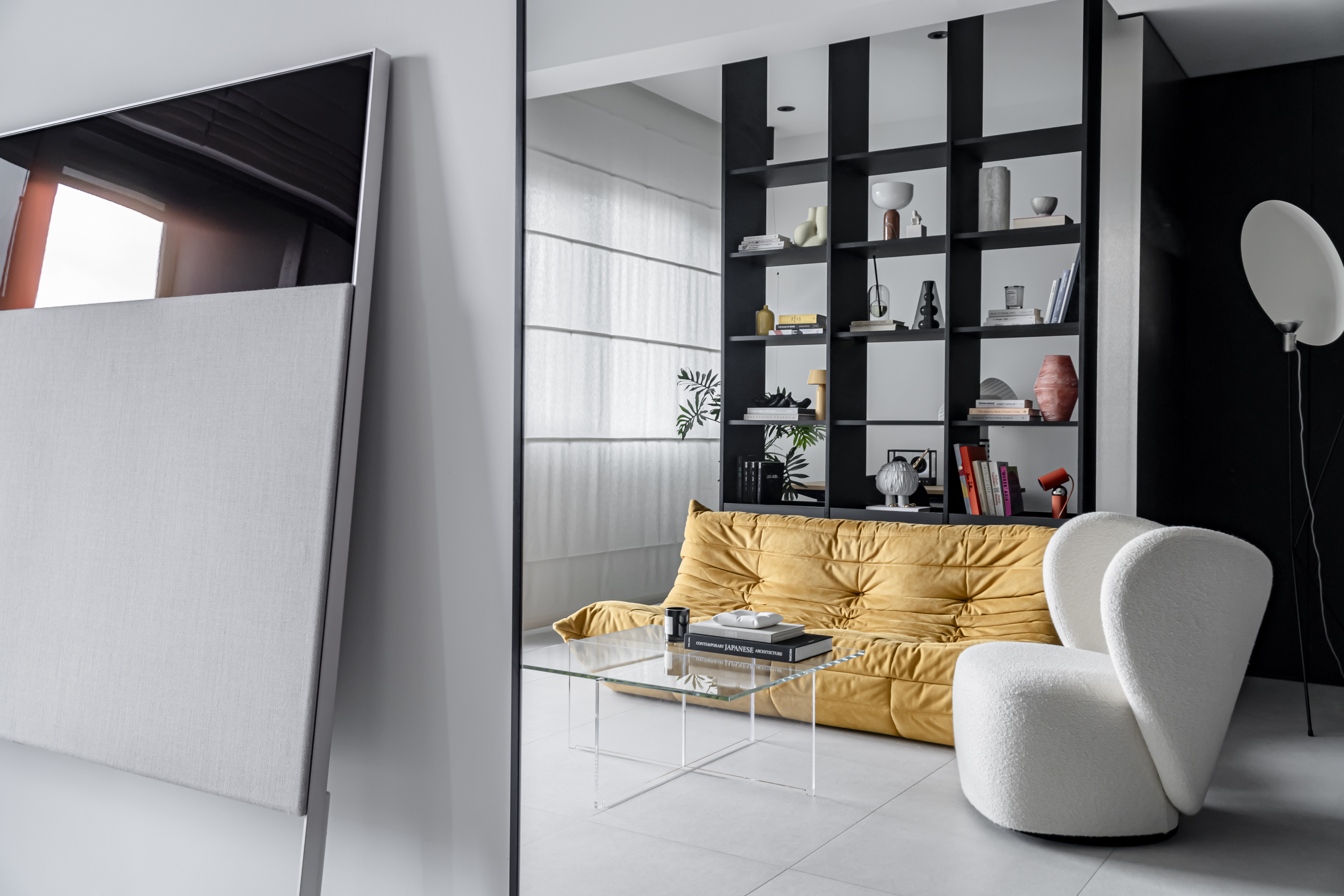 A Chic Modern Apartment Filled with Colors and Objects - Modern minimalist living room, sleek black shelving unit, yellow