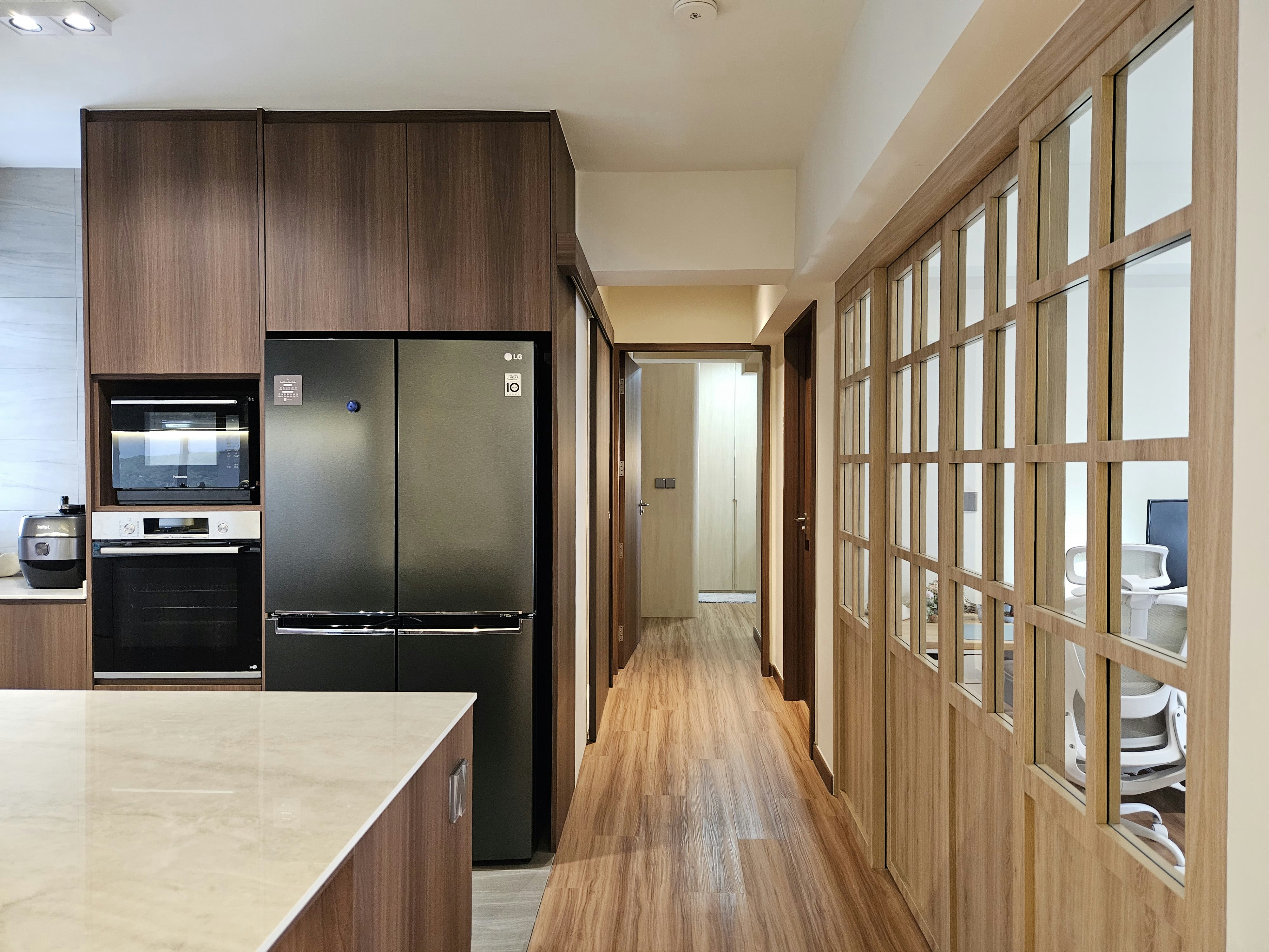 Step into our wood and pottery-filled 5-Room BTO - Wooden kitchen cabinetry, modern appliances, black refrigerator, stainless