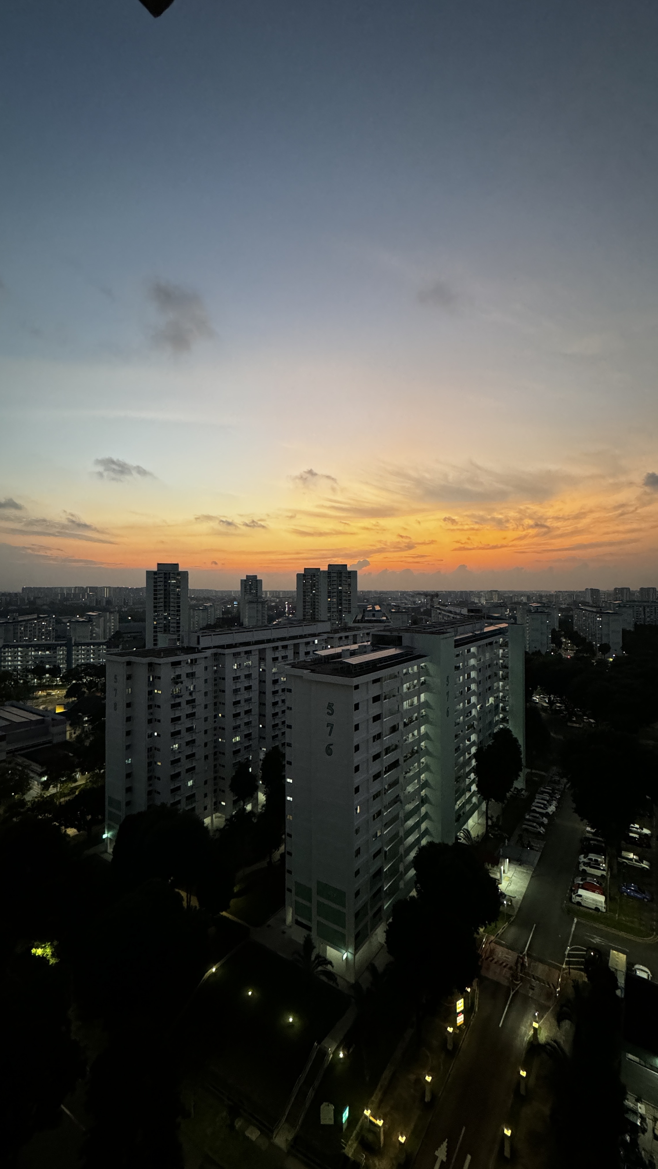 🏠 The Journey to Finding The Little Starry Loft - Towering residential buildings silhouetted against a vibrant sunset sky