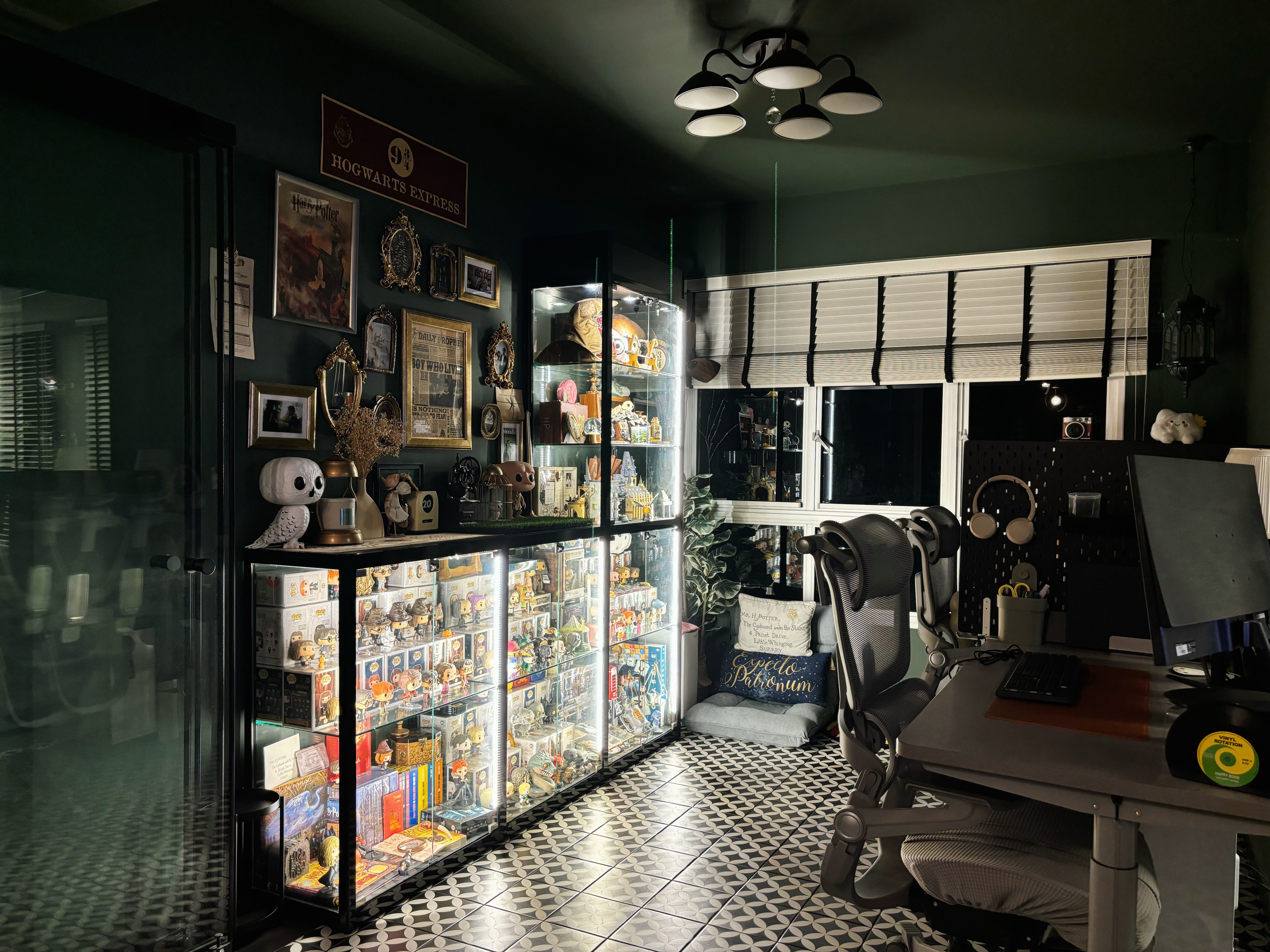 The Magic of Home by Potterhomeadventures - Glowing display case filled with Harry Potter memorabilia, black and white