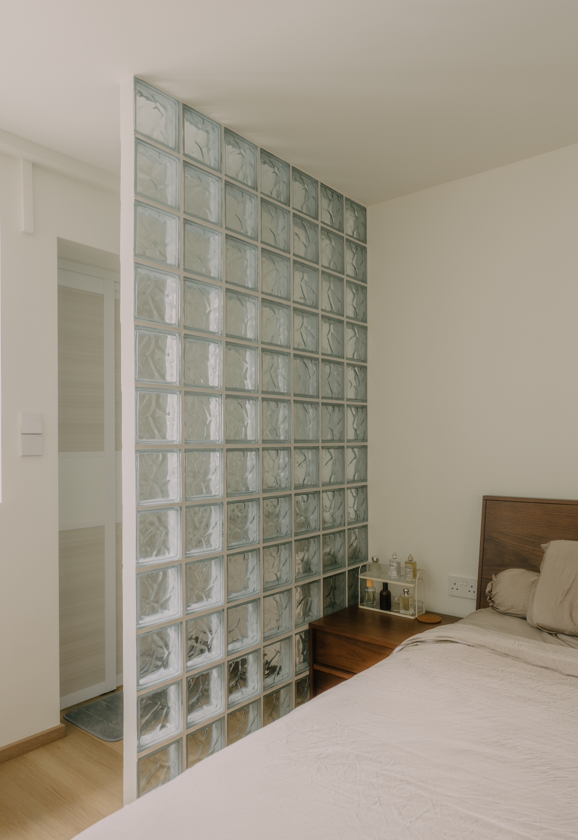 Cosy Neutral & Walnut-Themed Bedroom with a Retro Glass Block Wall  - Glass-paneled wall, minimalist design, modern decor