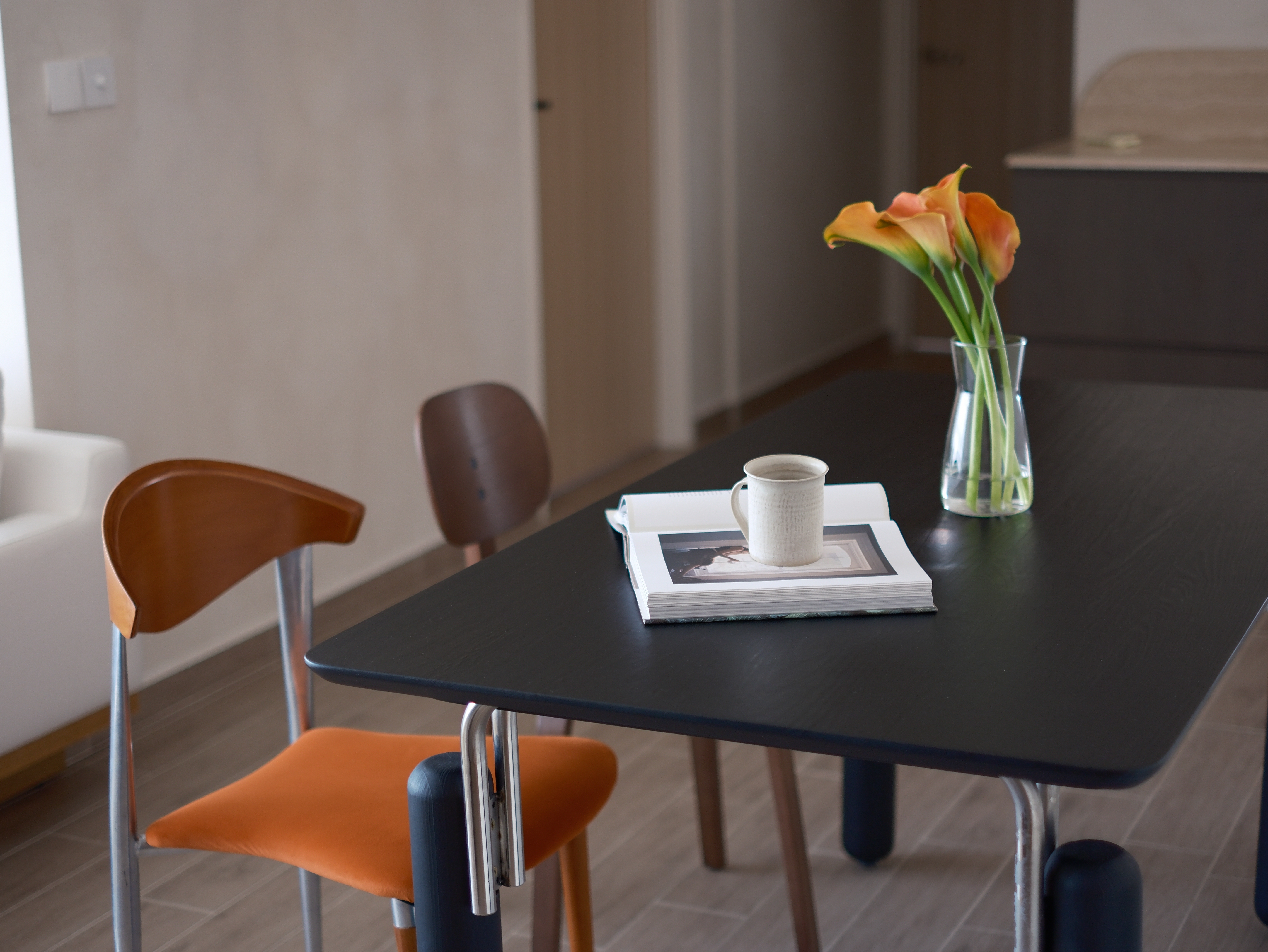 Embracing Minimalism in our Airy Dining Nook  - modern dining room, minimalist furniture, black table, orange chairs, white