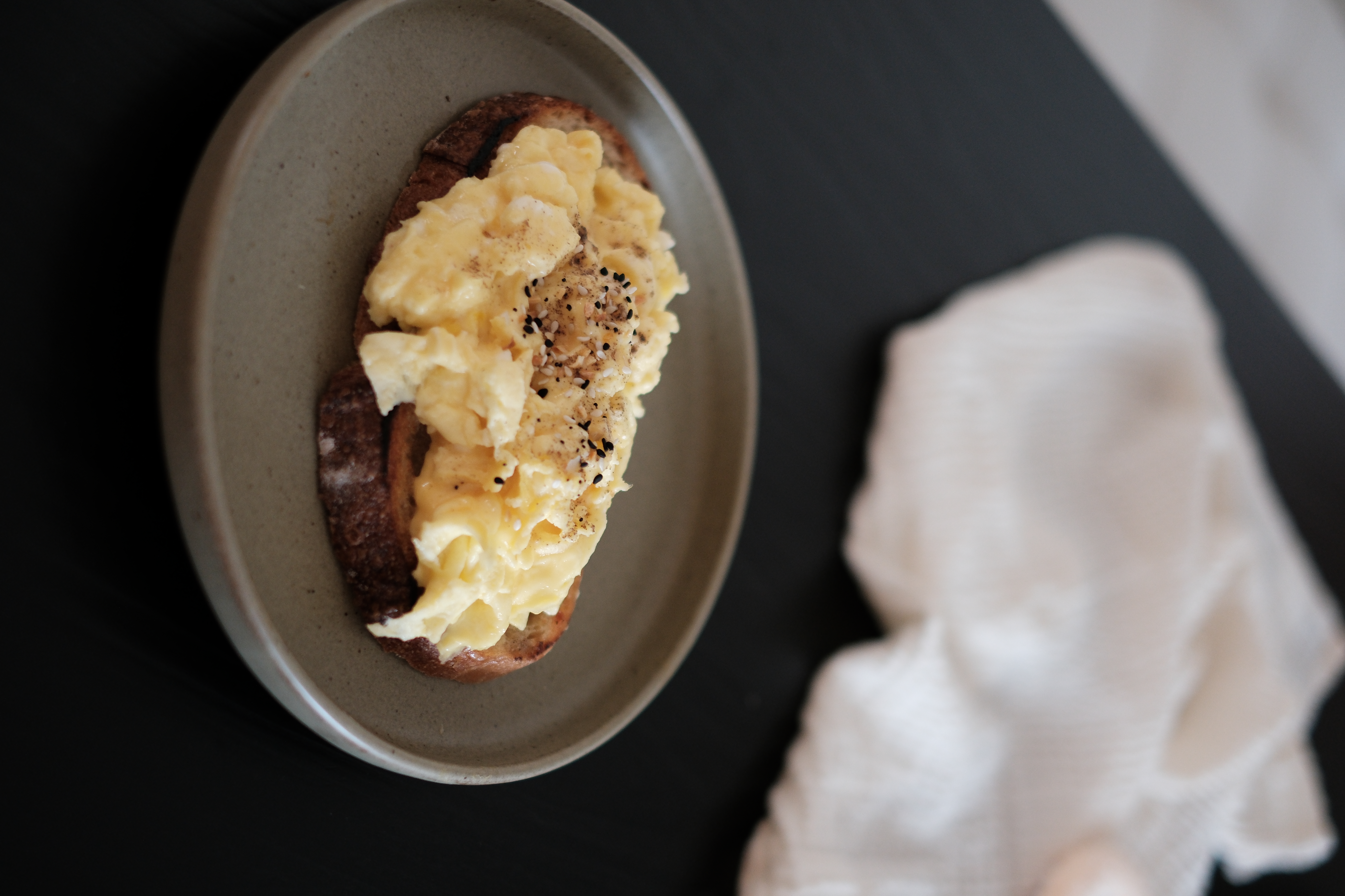 Embracing Minimalism in our Airy Dining Nook  - Grilled toast, scrambled eggs, black pepper, creamy texture, rustic
