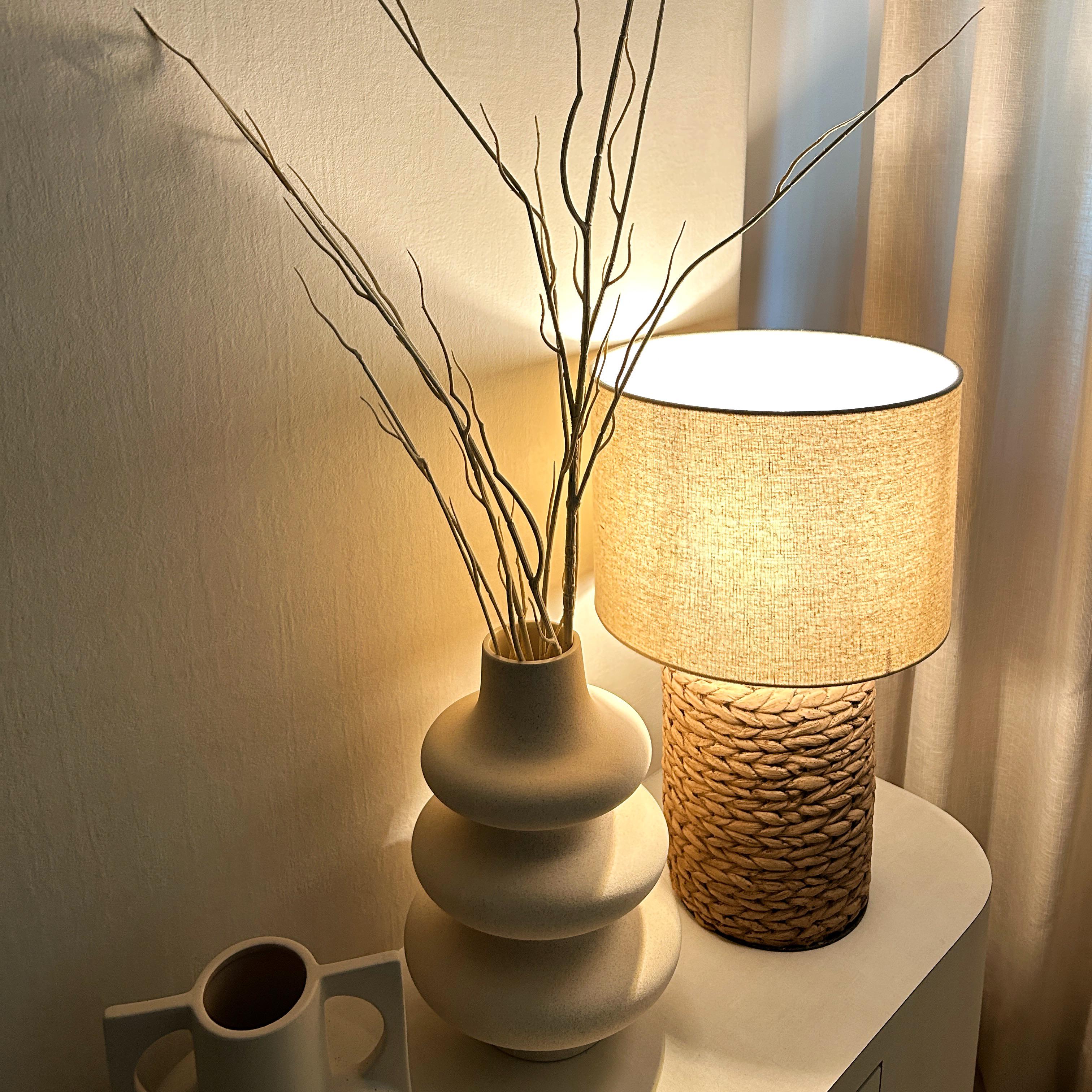 Creating Comfort: Our Personalized Home Decor - vase with dried branches, textured wall, soft lighting, rustic lampshade