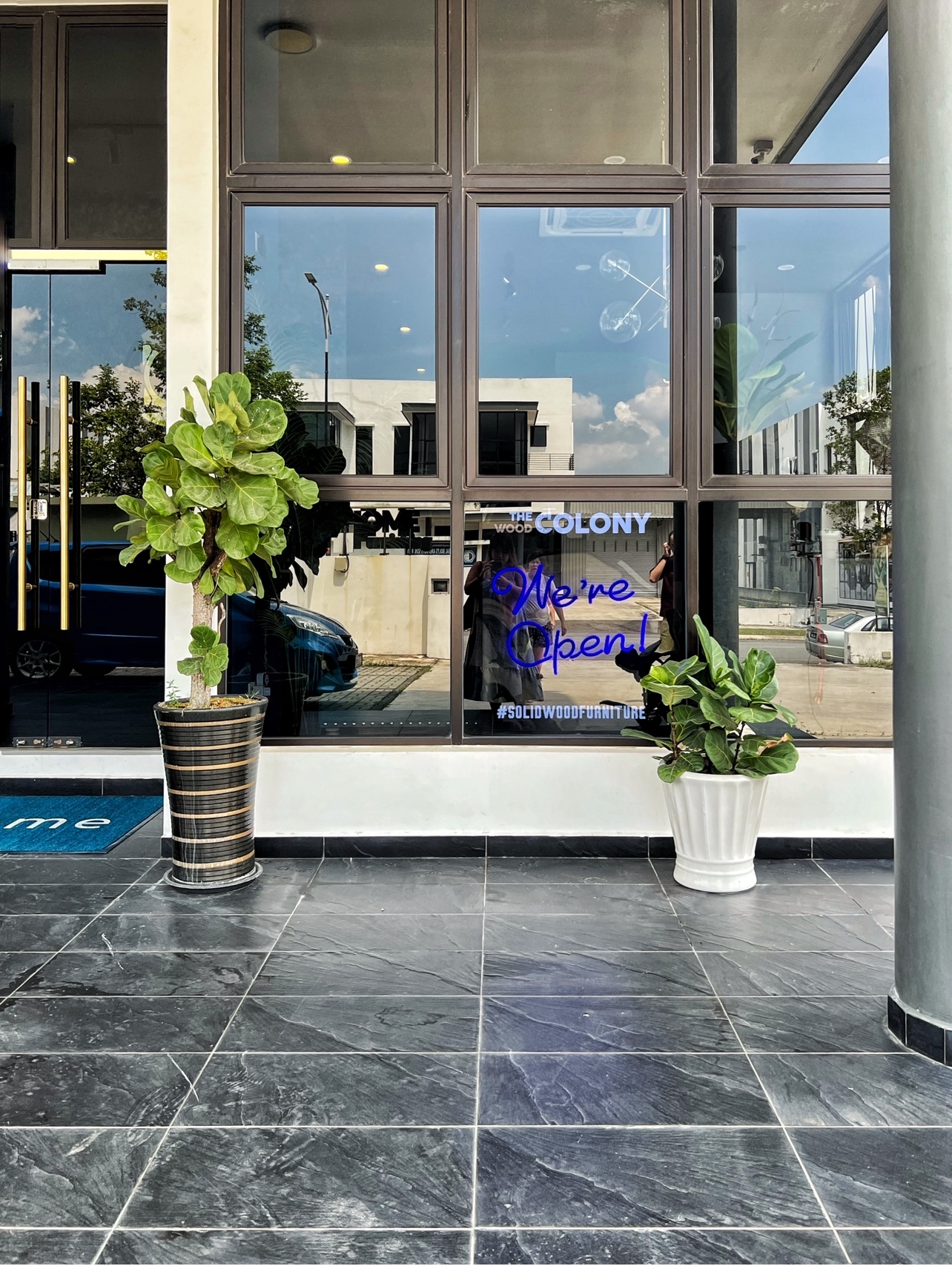 The Social Hub: Creating a space about connection and conversation - Modern storefront, large windows, blue neon sign, "We're