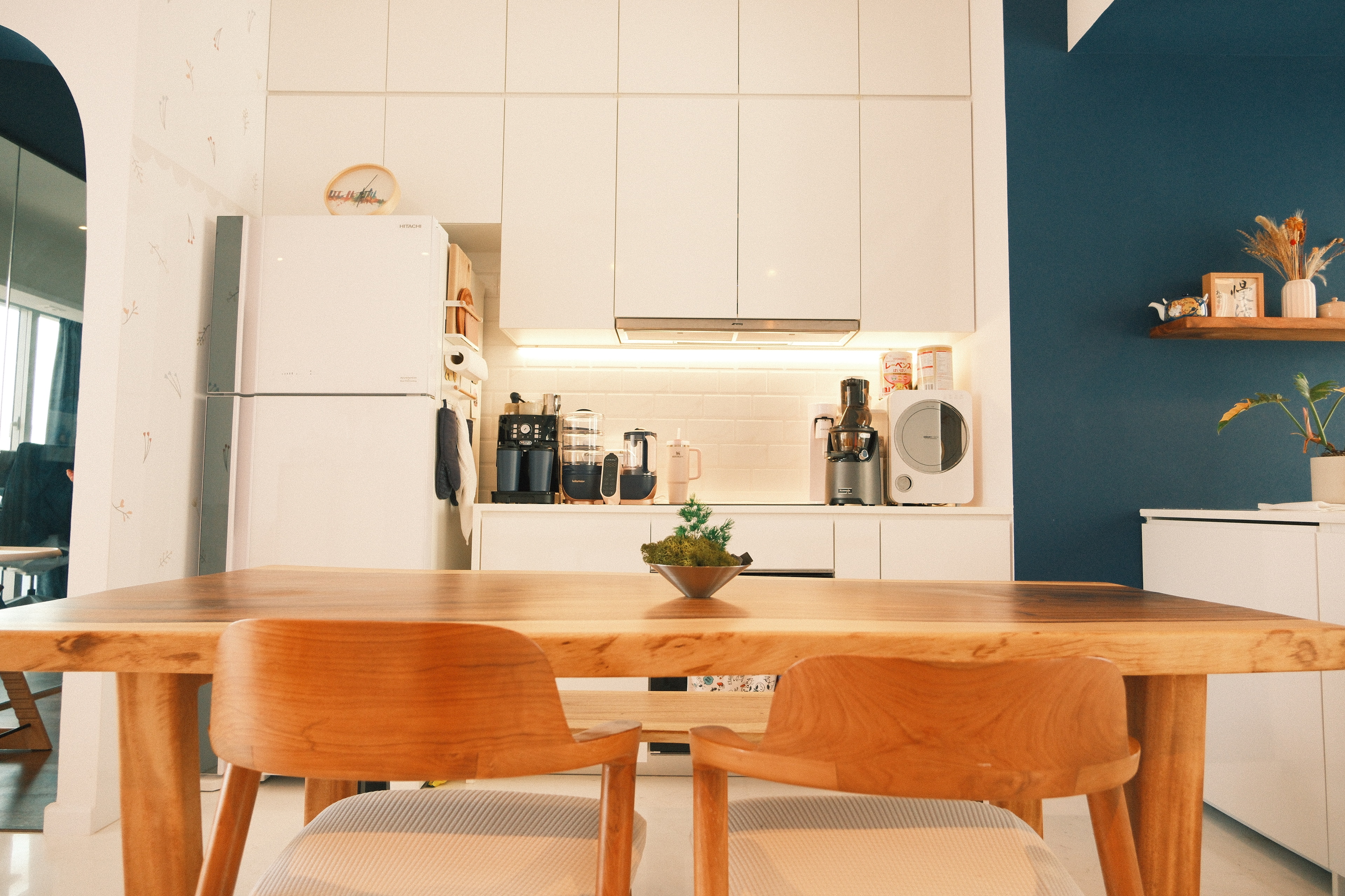 Wes Anderson-style dining room with warm woody tones  - modern kitchen, minimalist design, white cabinets, wooden dining