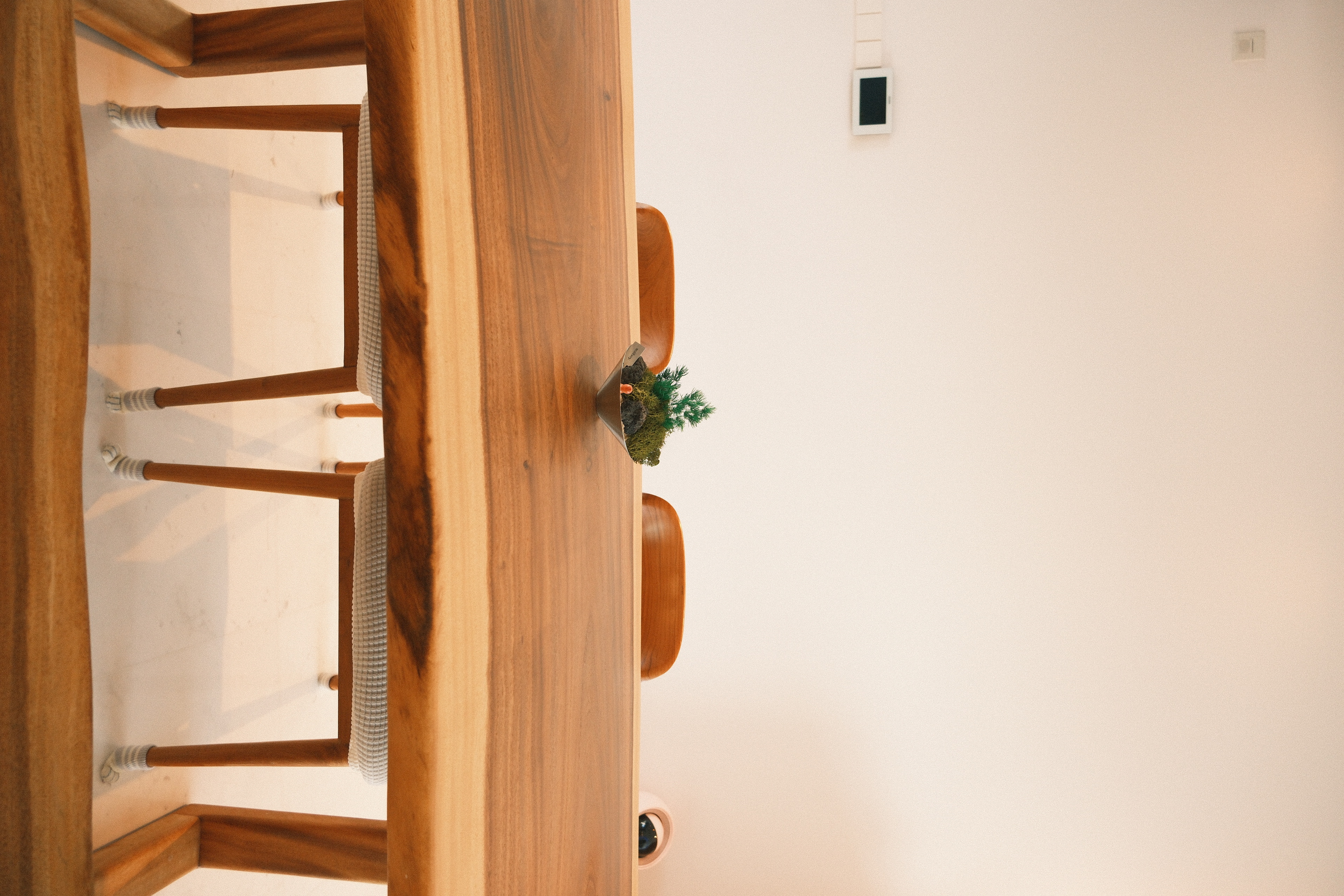 Wes Anderson-style dining room with warm woody tones  - Wooden dining table, minimalist design, wooden chairs, cozy room