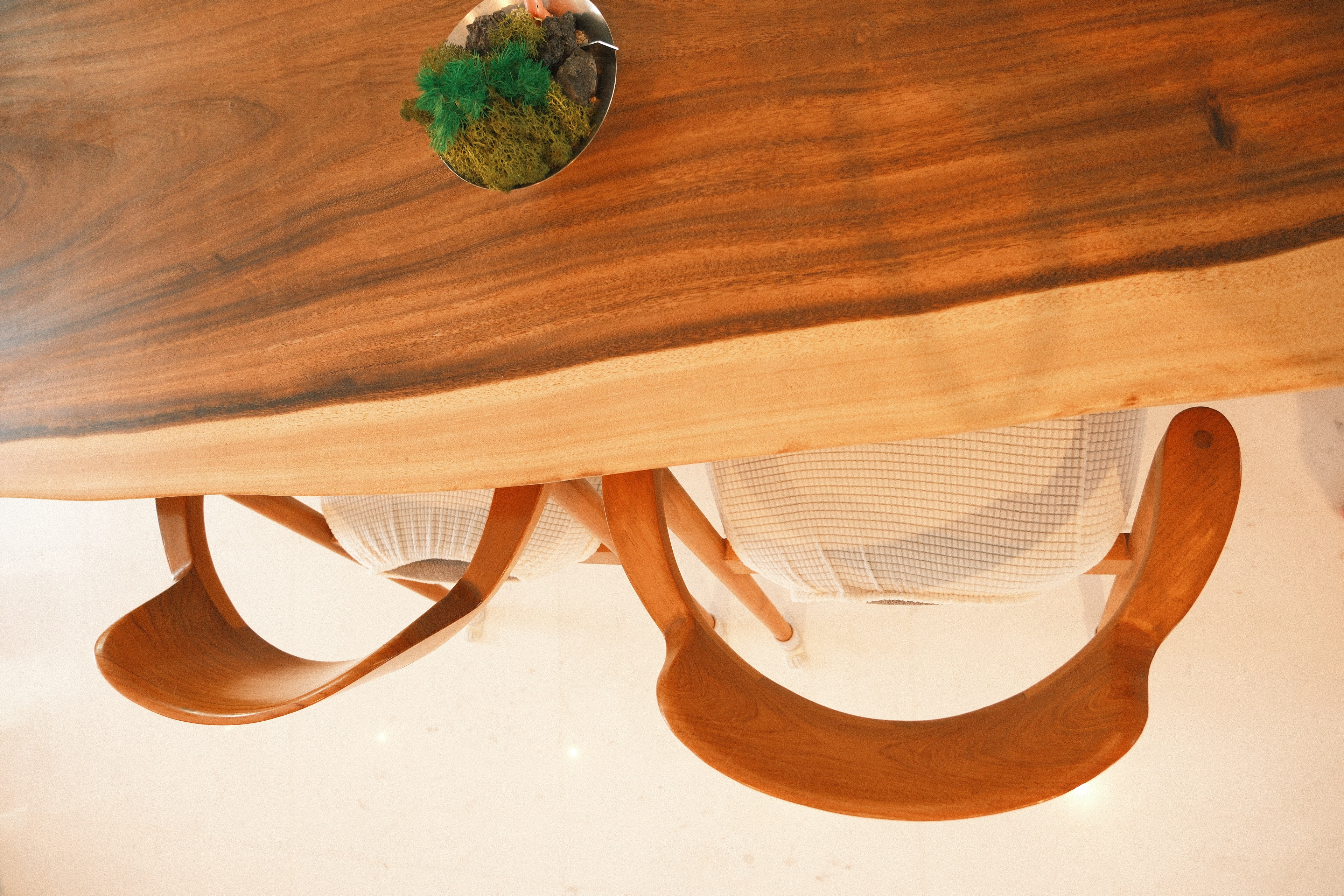 Wes Anderson-style dining room with warm woody tones  - Wooden dining table, minimalist design, natural wood grain, modern