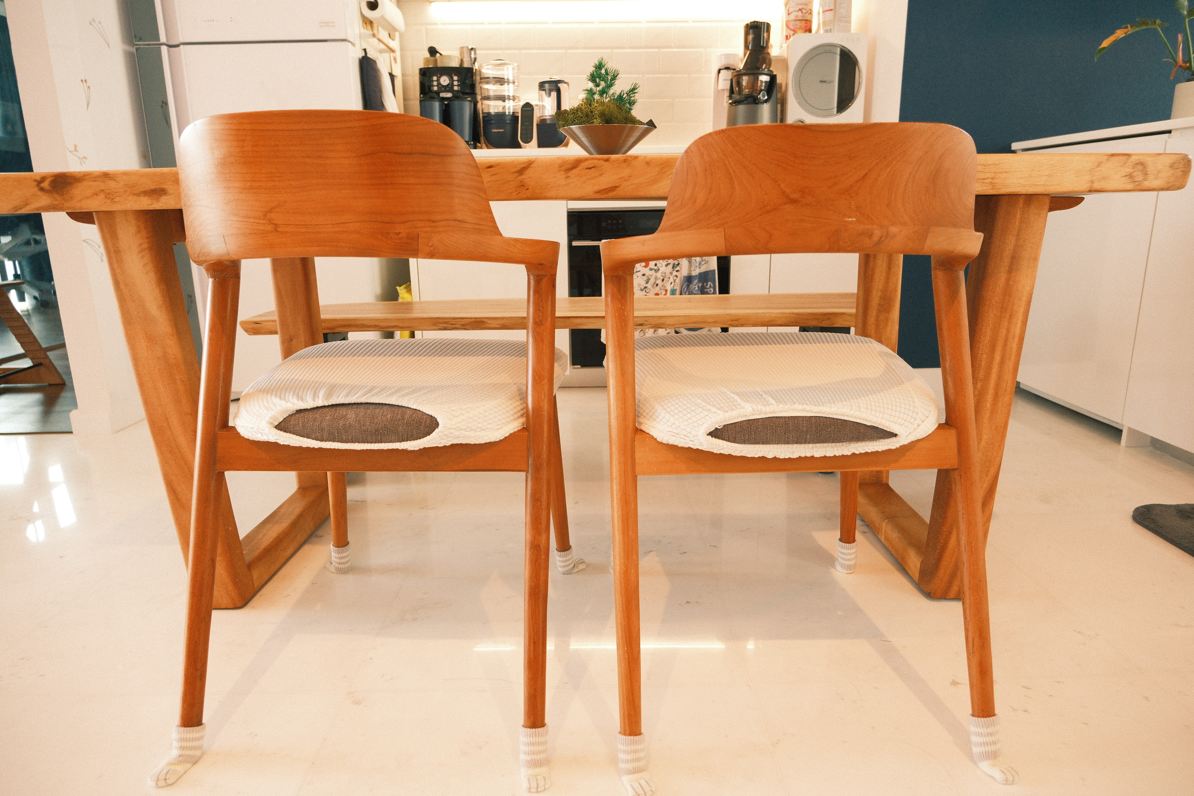Wes Anderson-style dining room with warm woody tones  - Wooden dining chairs, minimalist design, modern kitchen, cozy