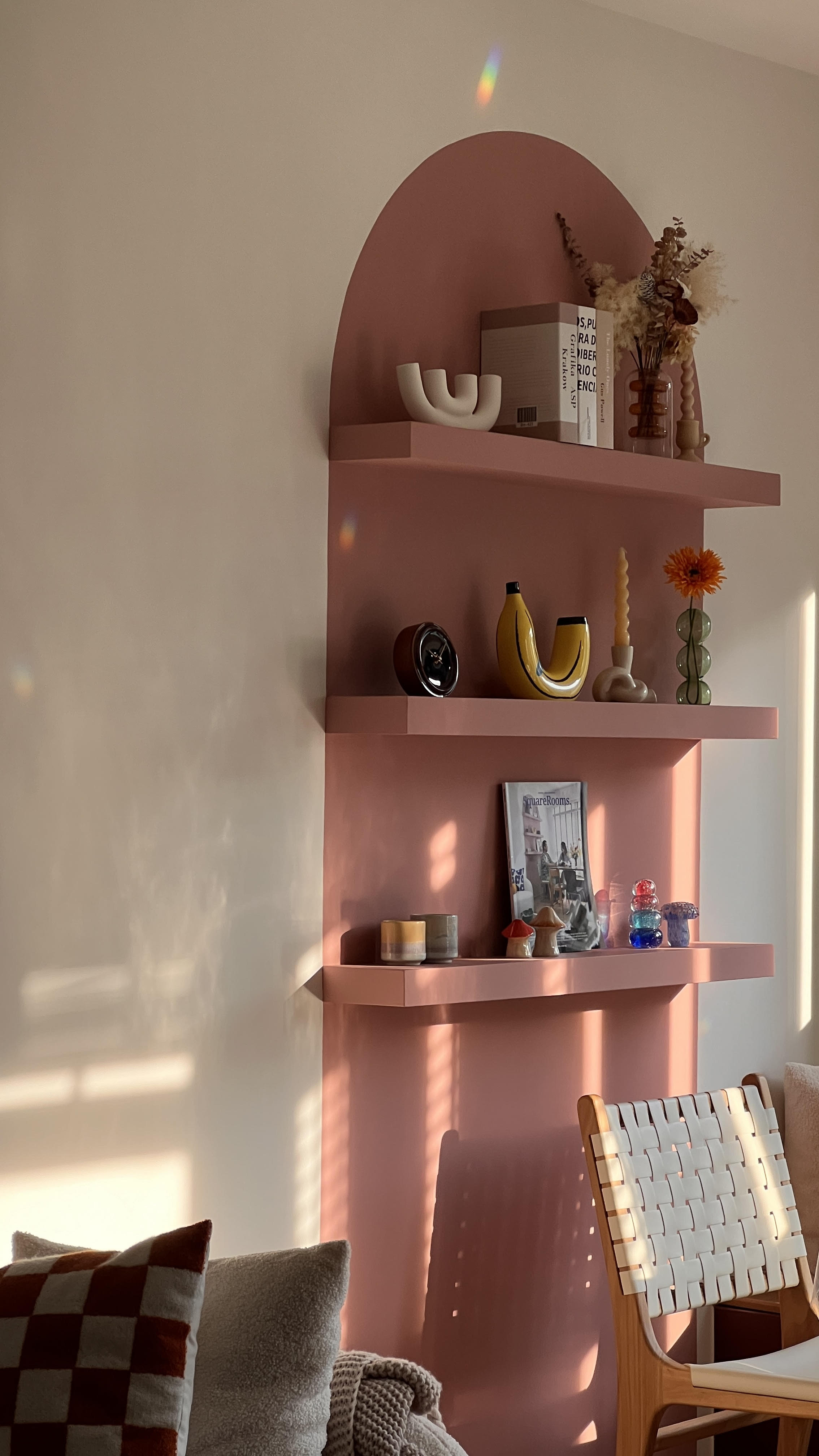A home is a mix of your personality and character - Shelf with decorative items, pink wall, sunlight casting shadows, cozy
