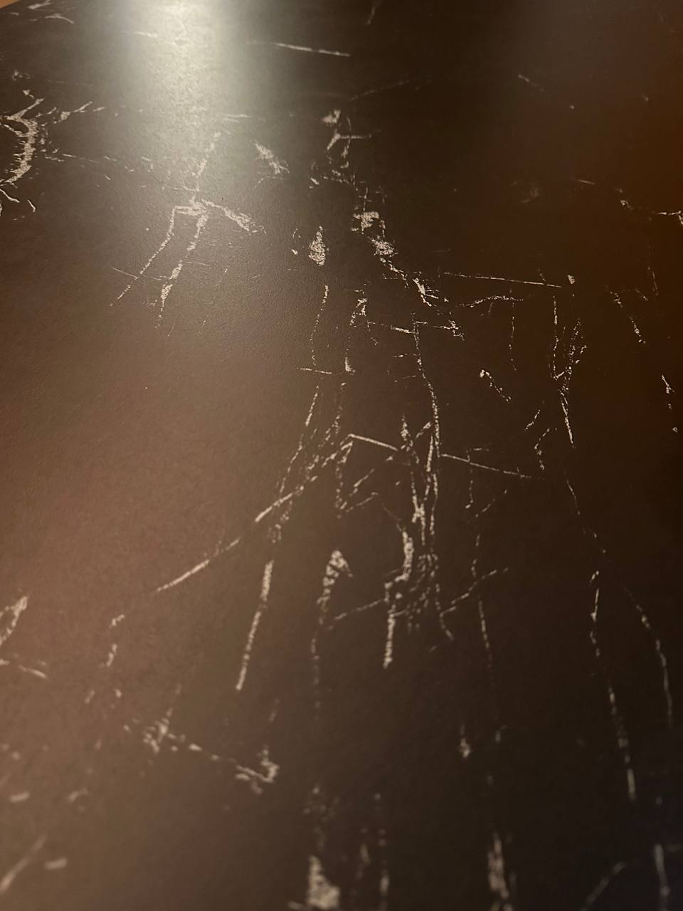 Cozy Dining Area - with Hidden Storage! - Dark, glossy surface, intricate cracks, shadowy ambiance, warm lighting, reflective