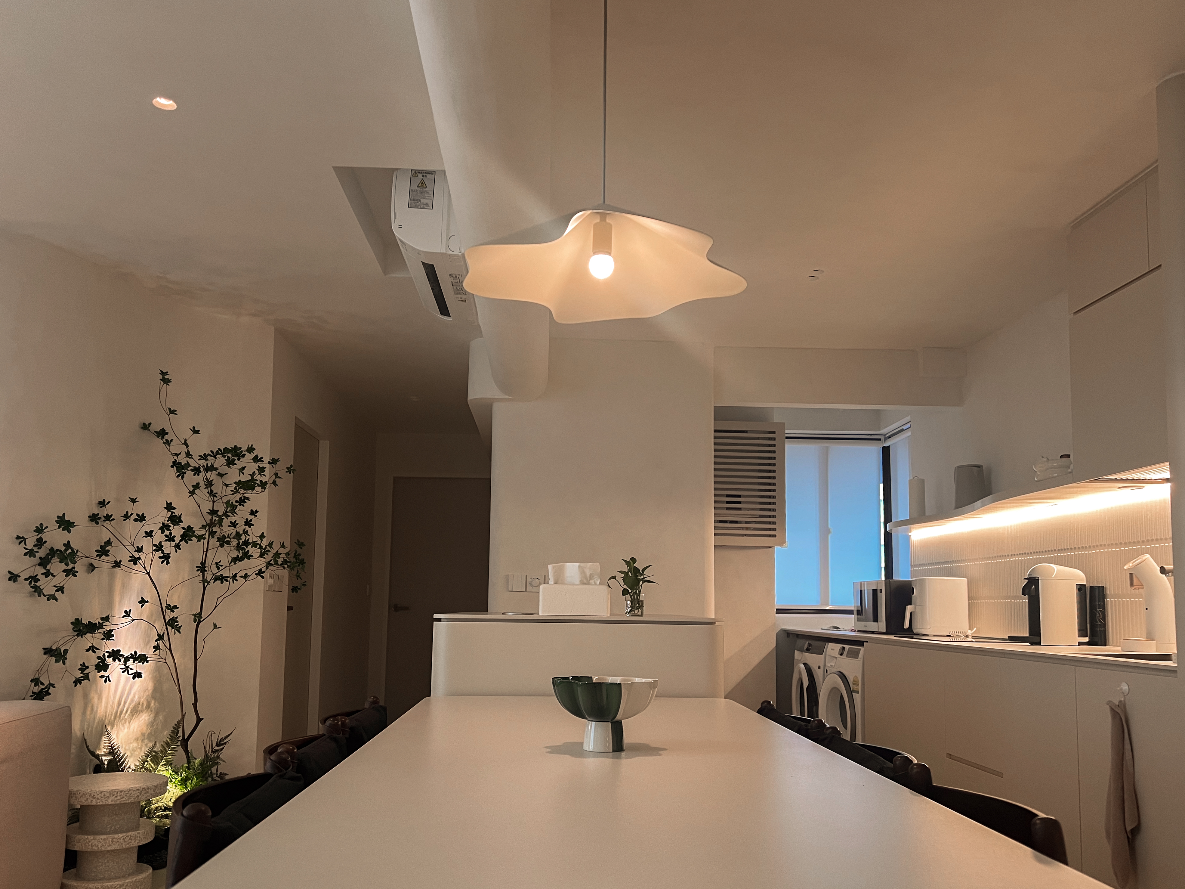 The difference between an Island and a Peninsula - Modern minimalist kitchen, sleek appliances, white cabinets, pendant