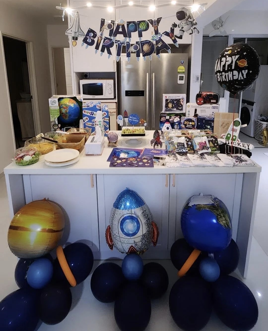 Hosting tips by punggoHField - birthday party, kitchen table, space-themed decorations, astronaut balloons, toy planet