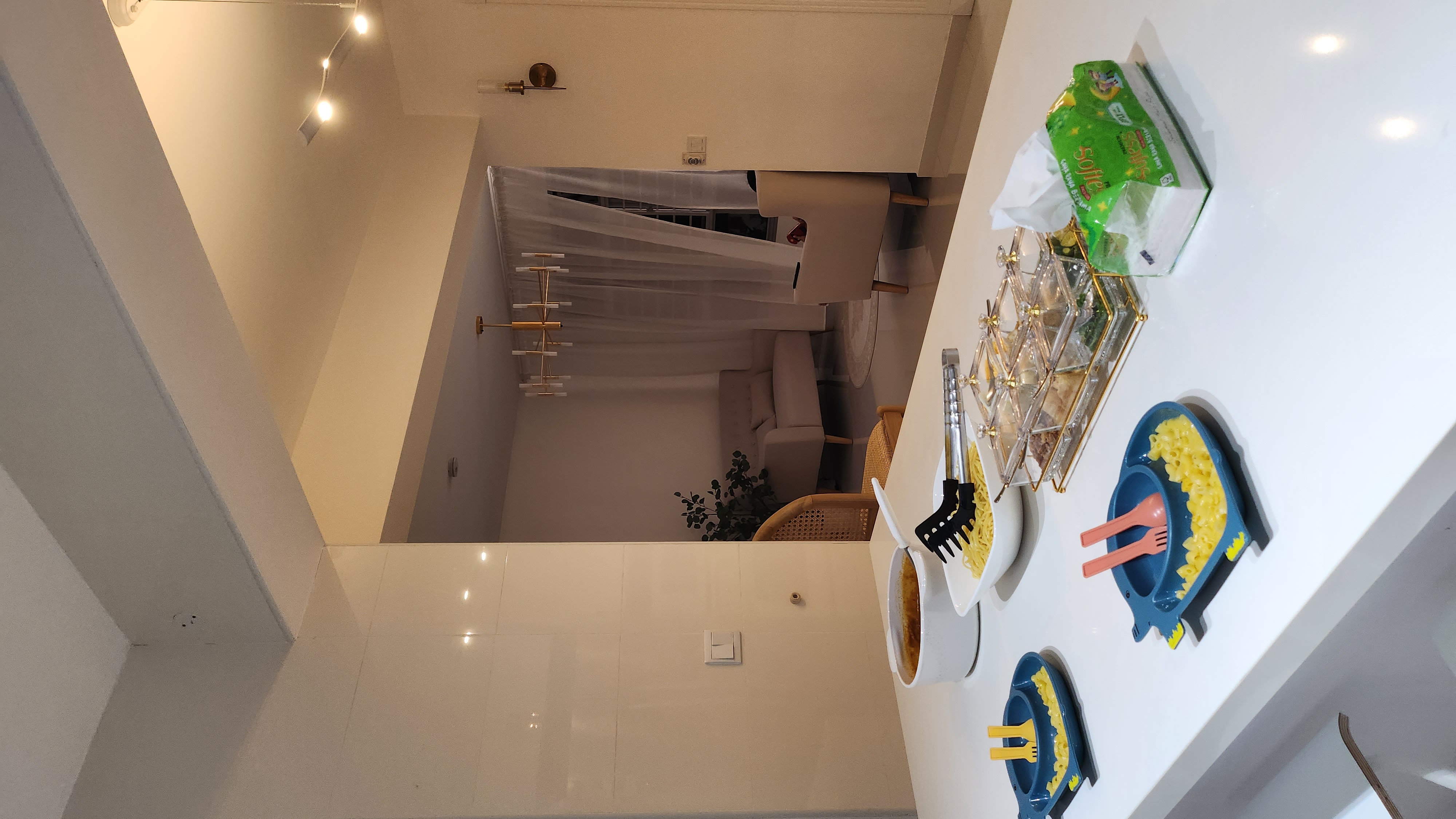 Hosting tips by punggoHField - Modern dining room, cozy atmosphere, white tiled walls, warm lighting, dining table, green bag