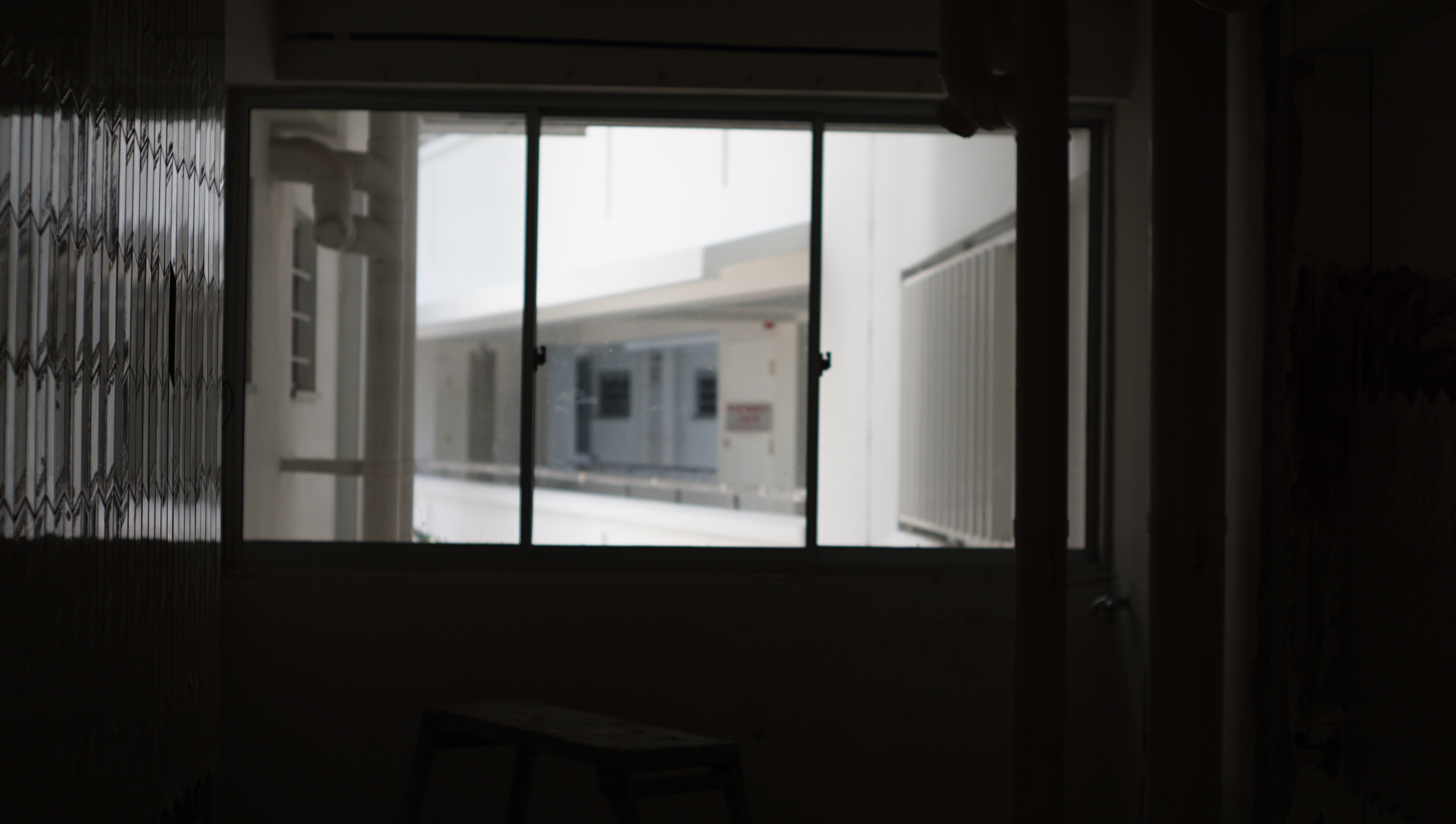 Finding a House and Making a Home - Dark room, dimly lit, window, blinds, shadows, light filtering, indoor setting, small