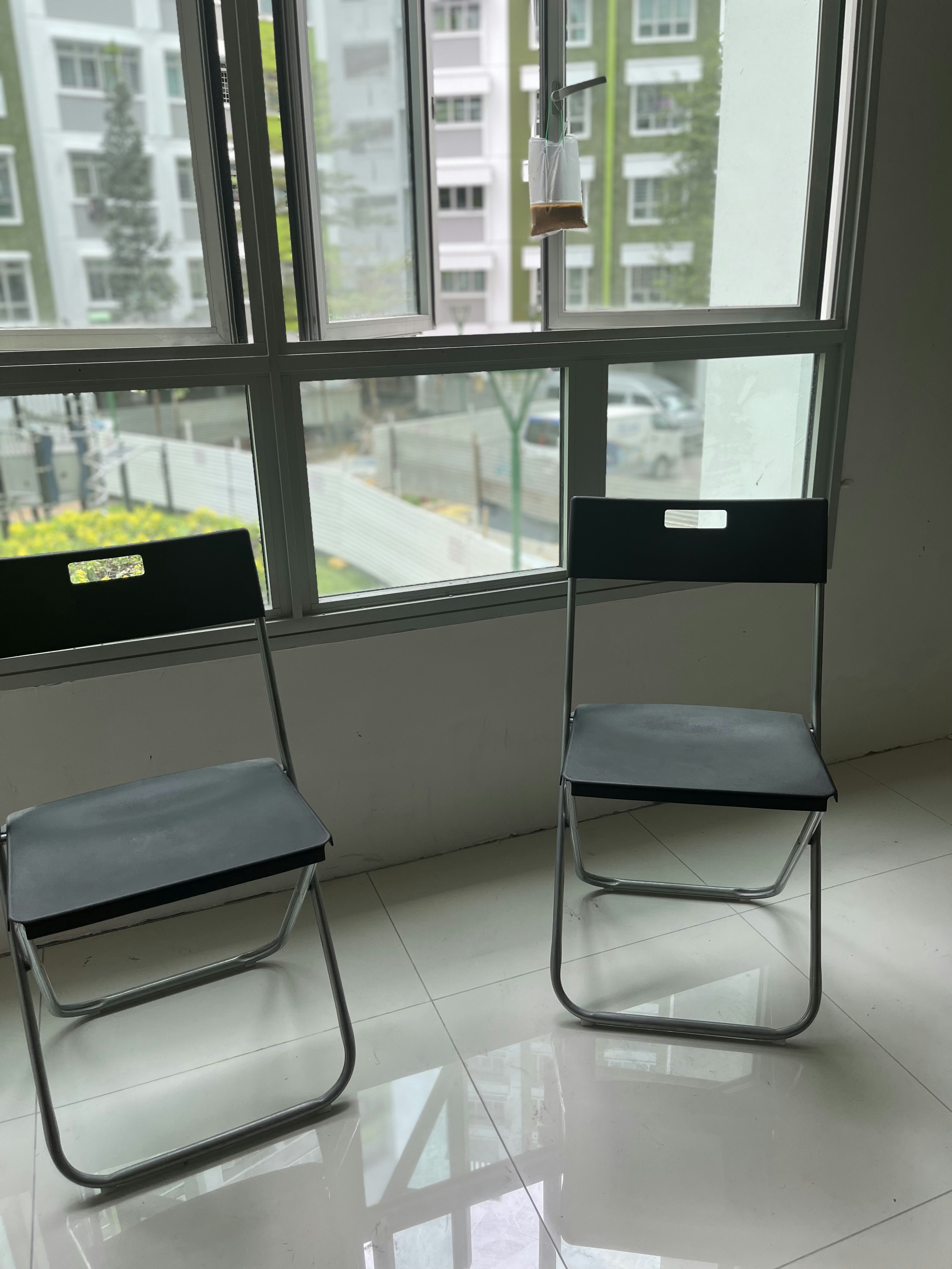 Finding a House and Making a Home - Modern minimalist interior, two black chairs, reflective tiled floor, large window with