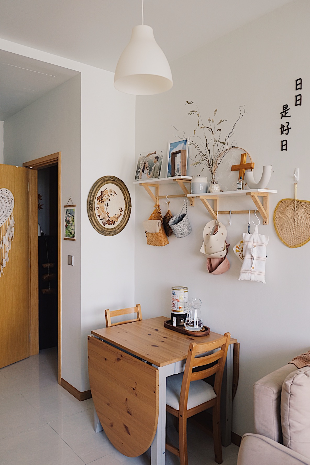 Styling a cosy dining nook in a small home - Wooden dining table, minimalist decor, white pendant light, wooden chairs, cozy