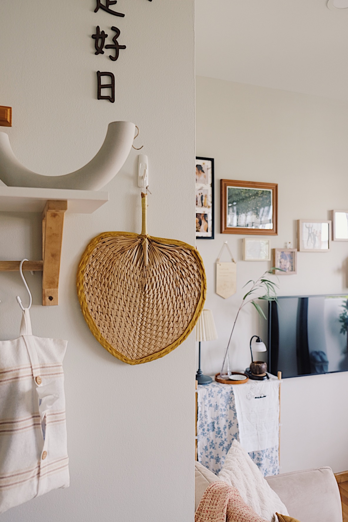 Styling a cosy dining nook in a small home - Woven heart-shaped decoration, white and beige striped shirt, wooden shelf