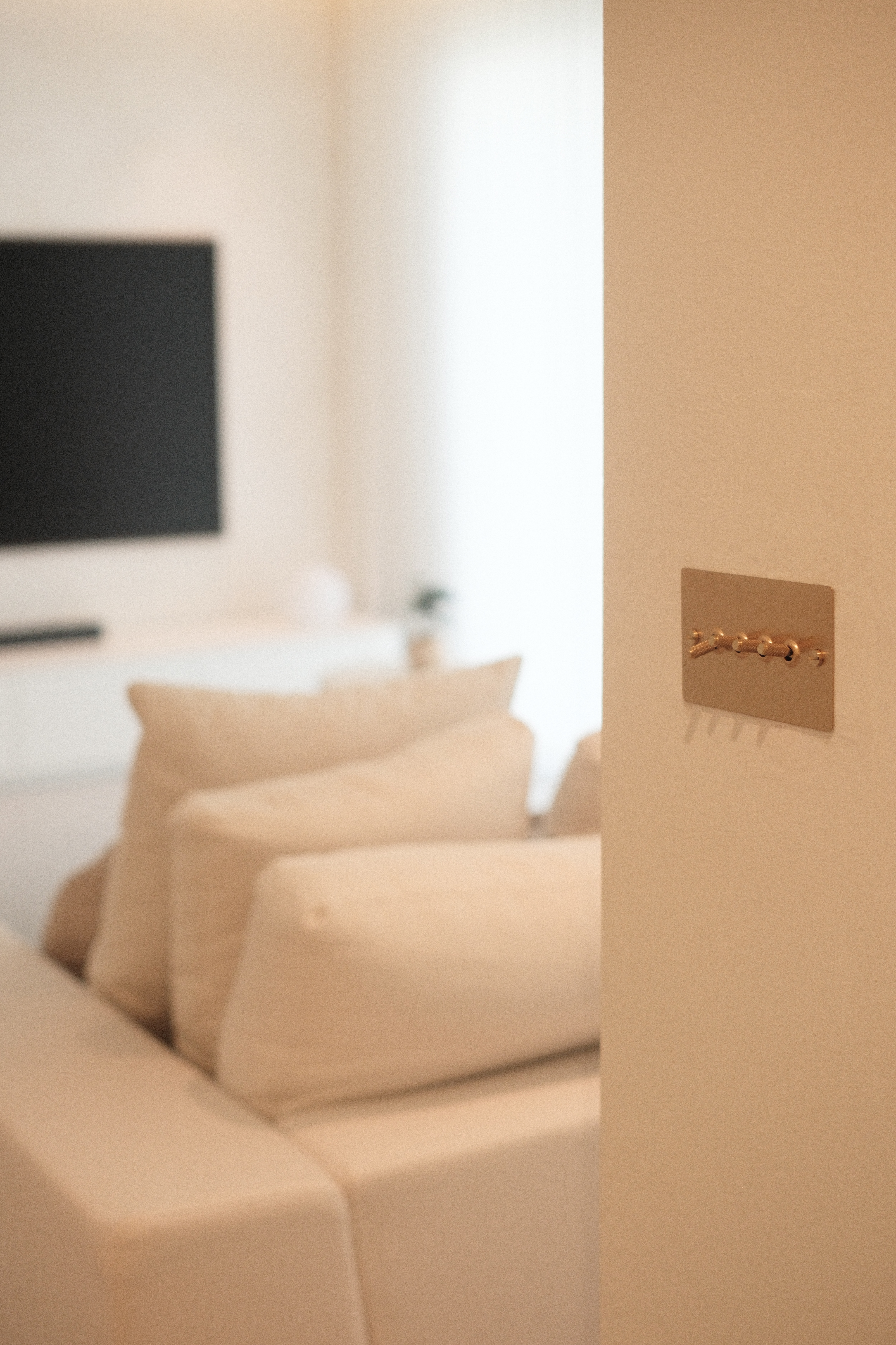 Our Living Room: Go Cream Or Go Home - Modern minimalist living room, neutral color palette, beige sofa, white cushions, soft