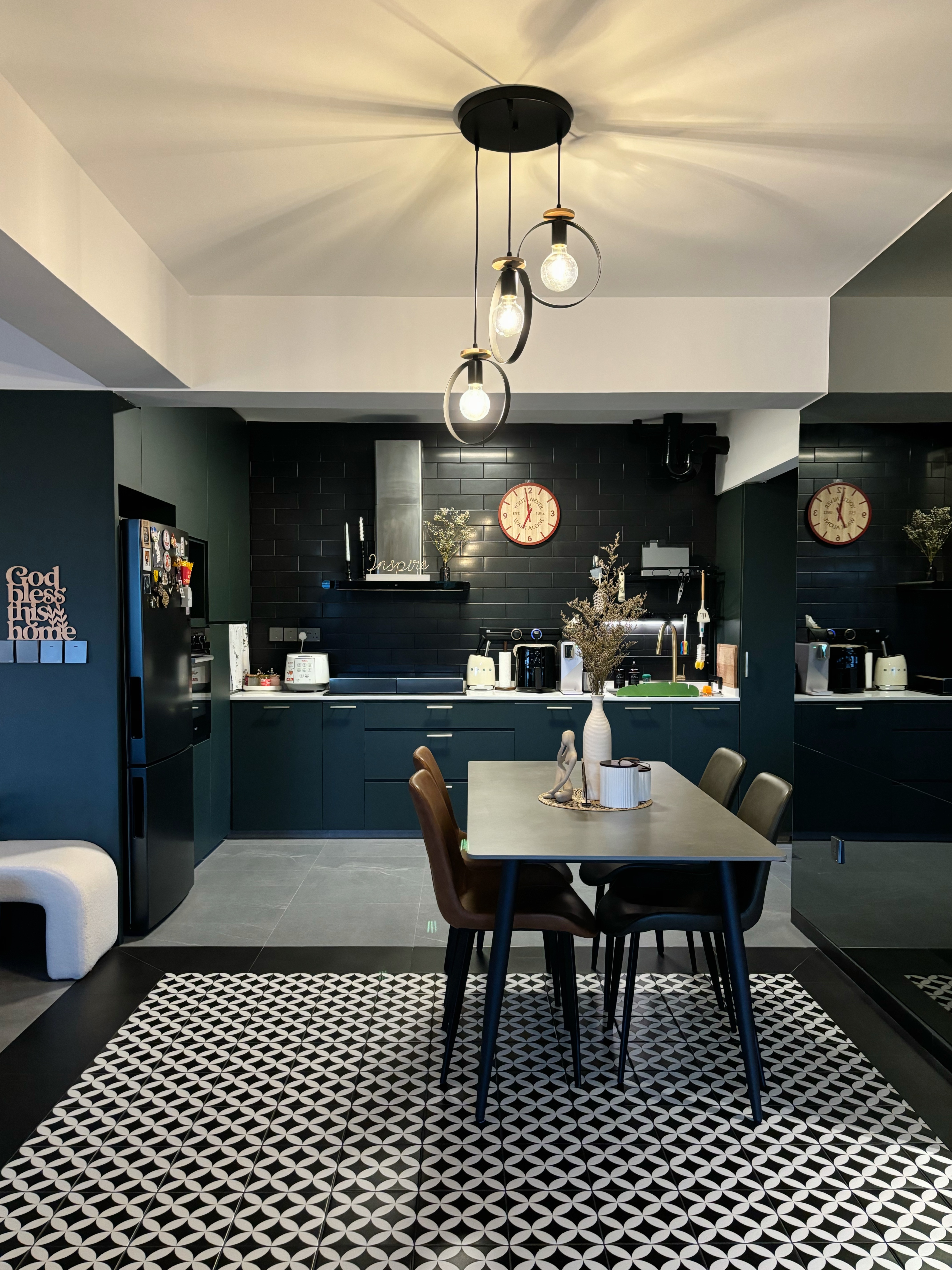 Meal and Greet - Modern kitchen with sleek black cabinets and countertops, minimalist design, contemporary lighting fixtures