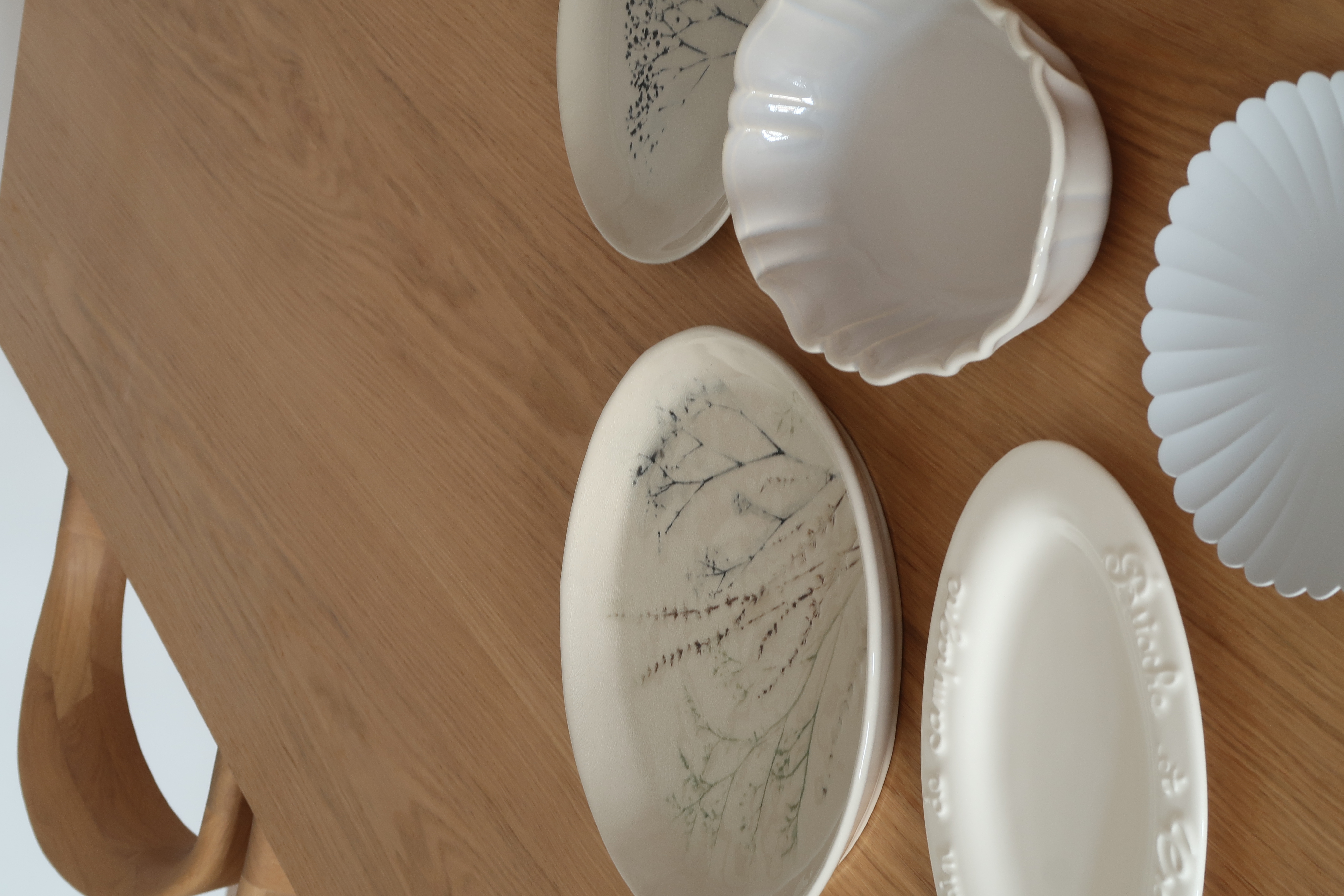 Dining Space: A Cosy Haven for Gatherings and More - Wooden table, ceramic plates, blue leaf designs, oval plates, scalloped