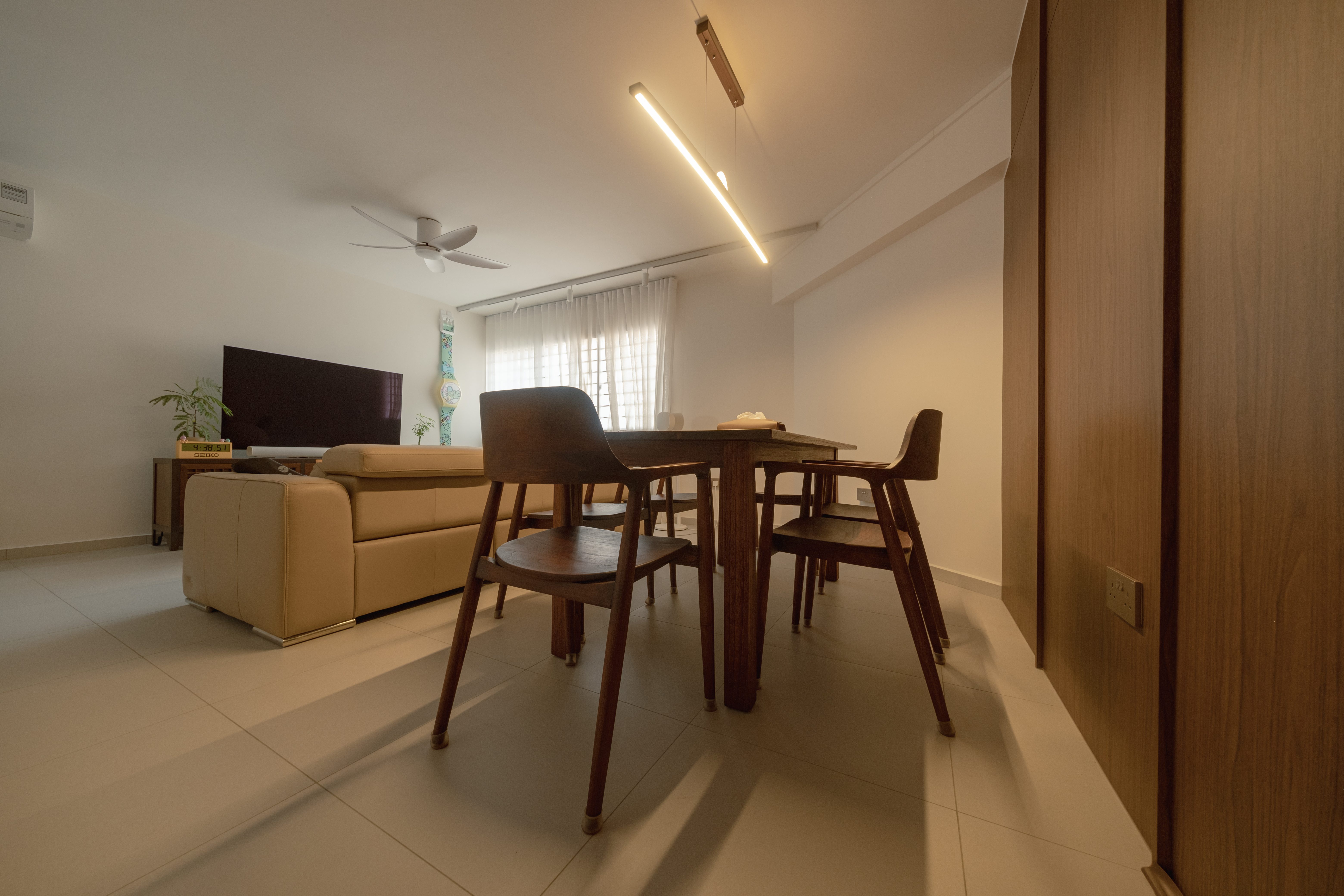 A Place to Gather: Our Dining Room Story - Modern living room with beige sofa, wooden dining table and chairs, ceiling fan