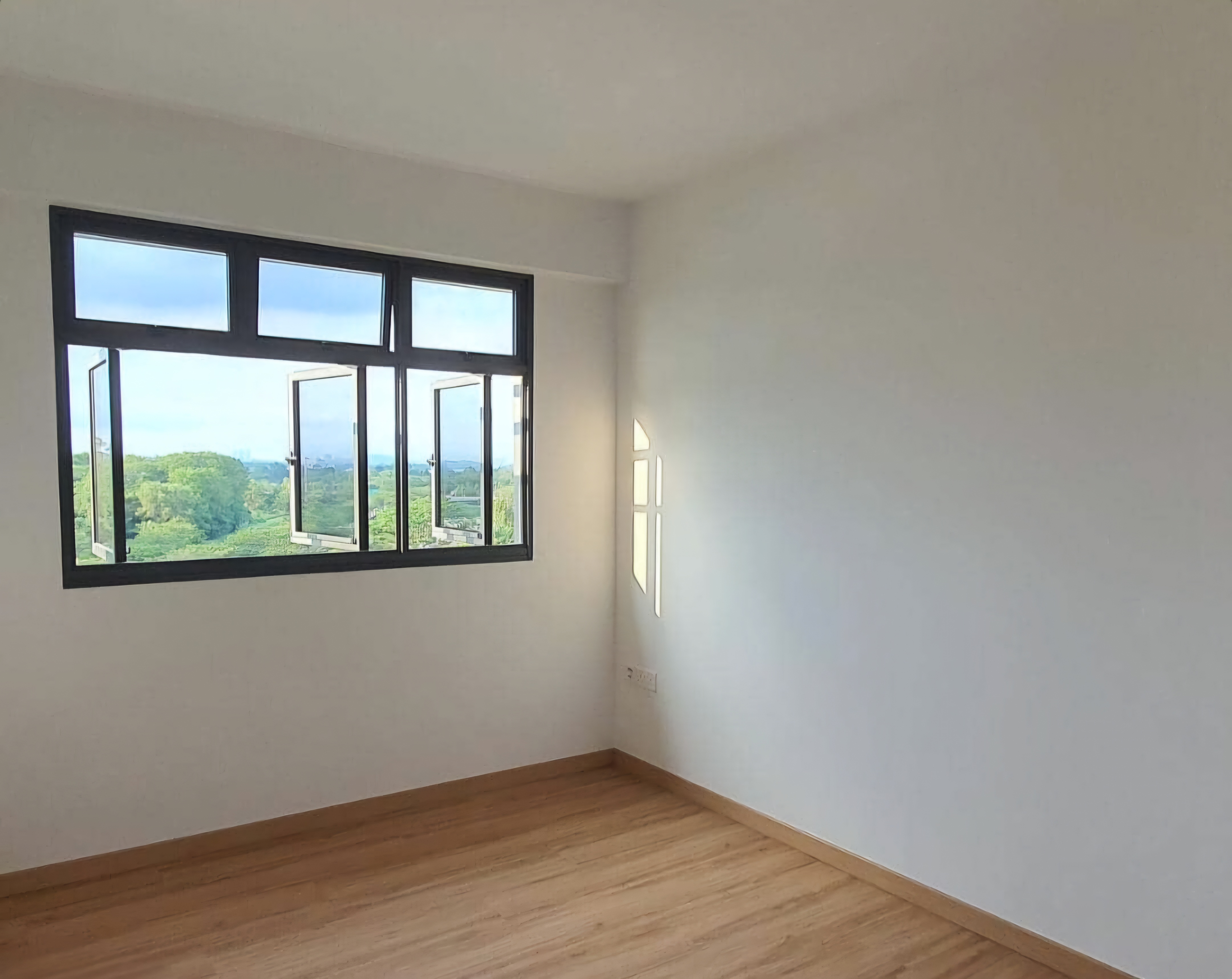 Renders vs. Reality: A Visual Journey - Bright room, white walls, wooden floor, large window, natural light, outdoor view