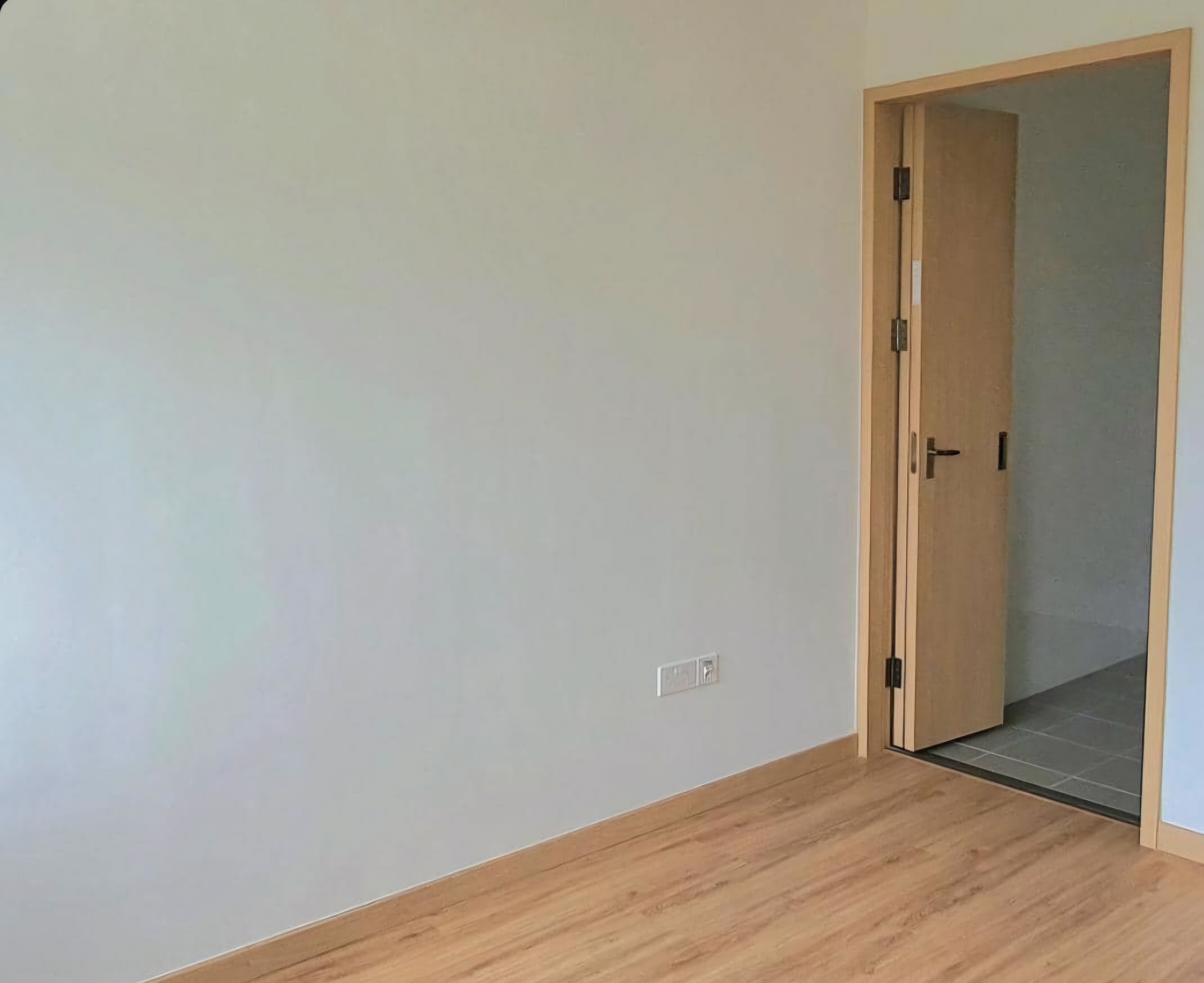 Renders vs. Reality: A Visual Journey - Minimalist room, light-colored walls, wooden flooring, open door, wooden door frame