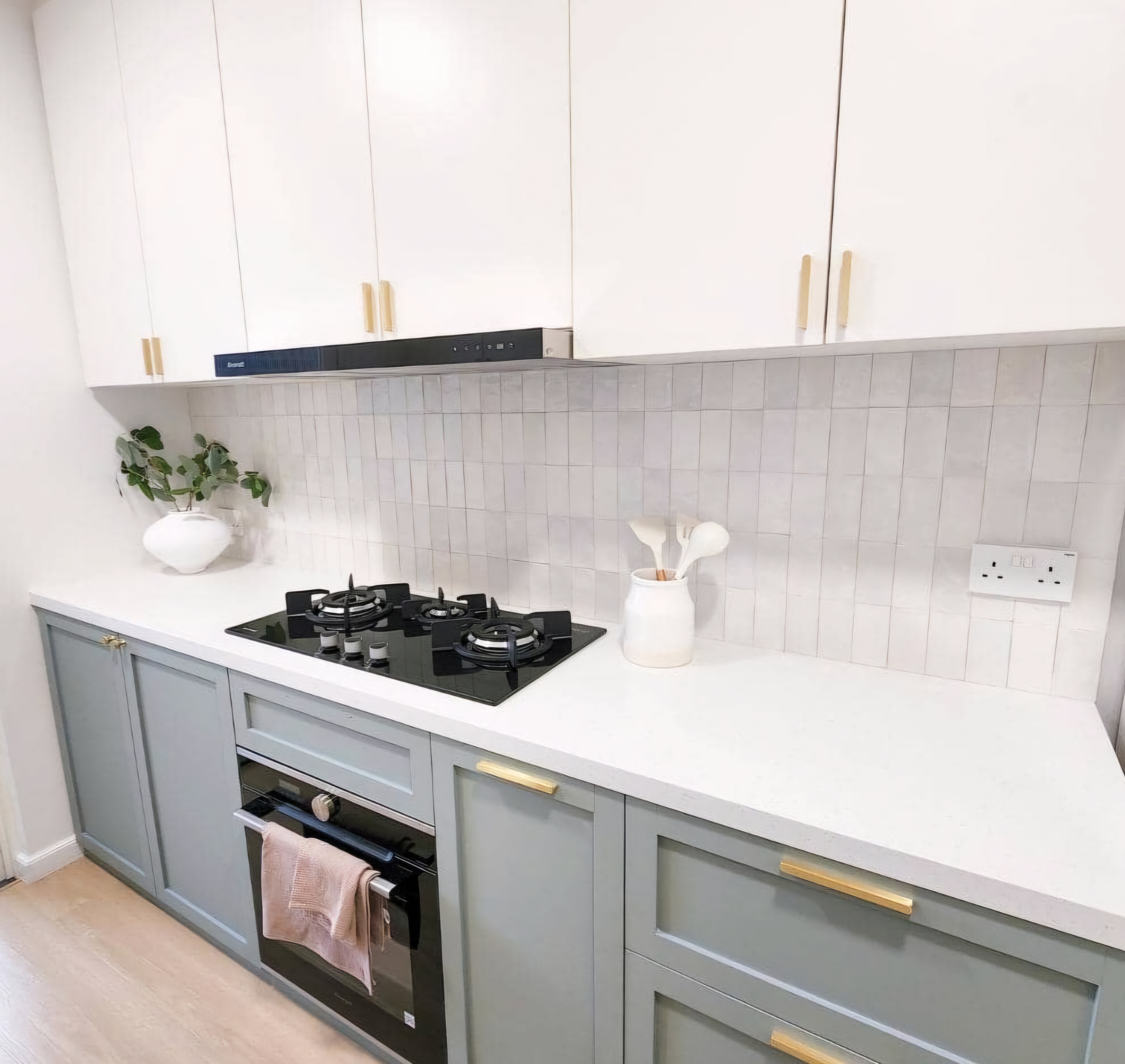 Renders vs. Reality: A Visual Journey - White kitchen cabinets, light gray countertops, black gas stove, white tiled