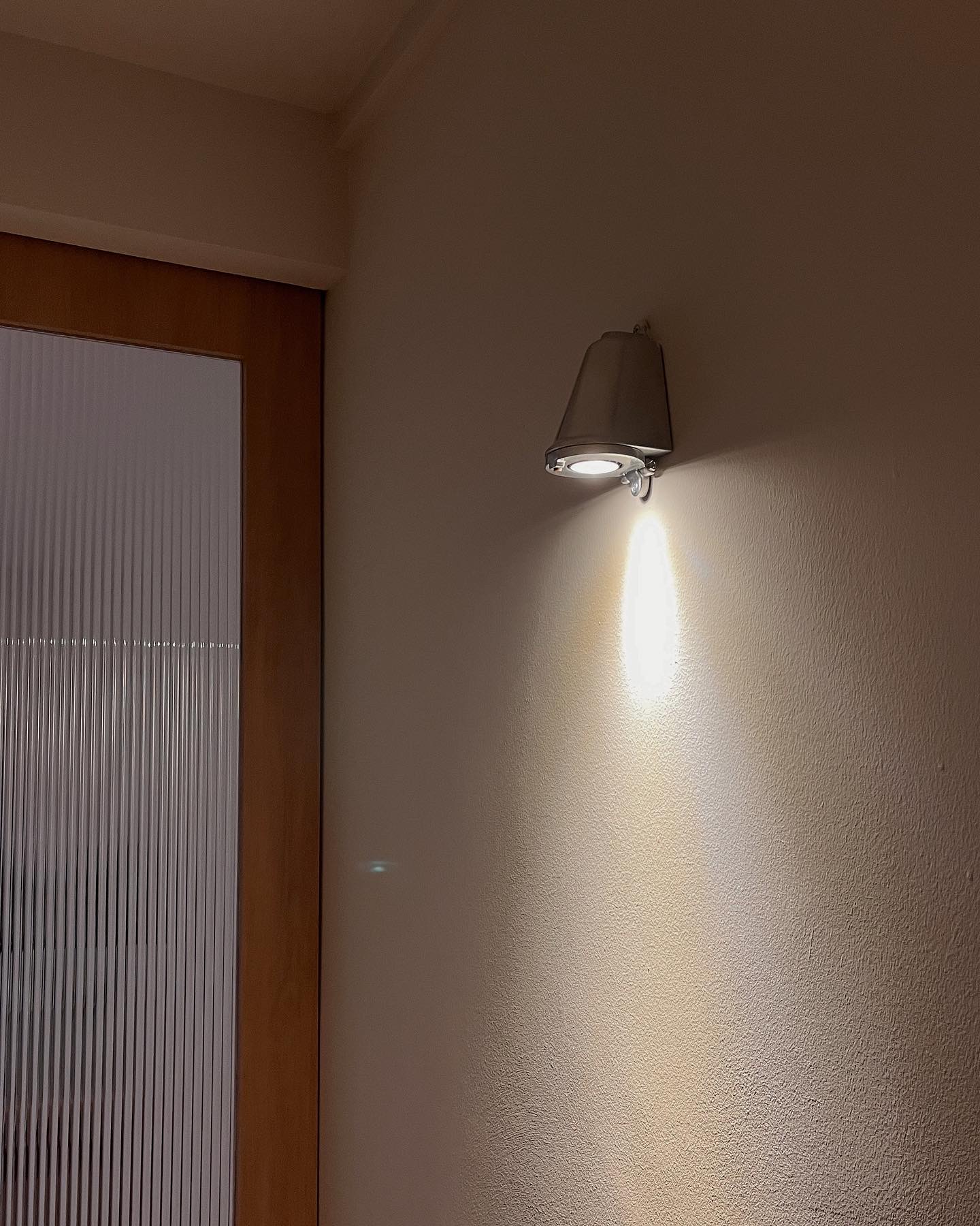 Home Styling: Tips to create a Cozy and Inviting Space - Modern wall-mounted light fixture, soft ambient lighting, sleek