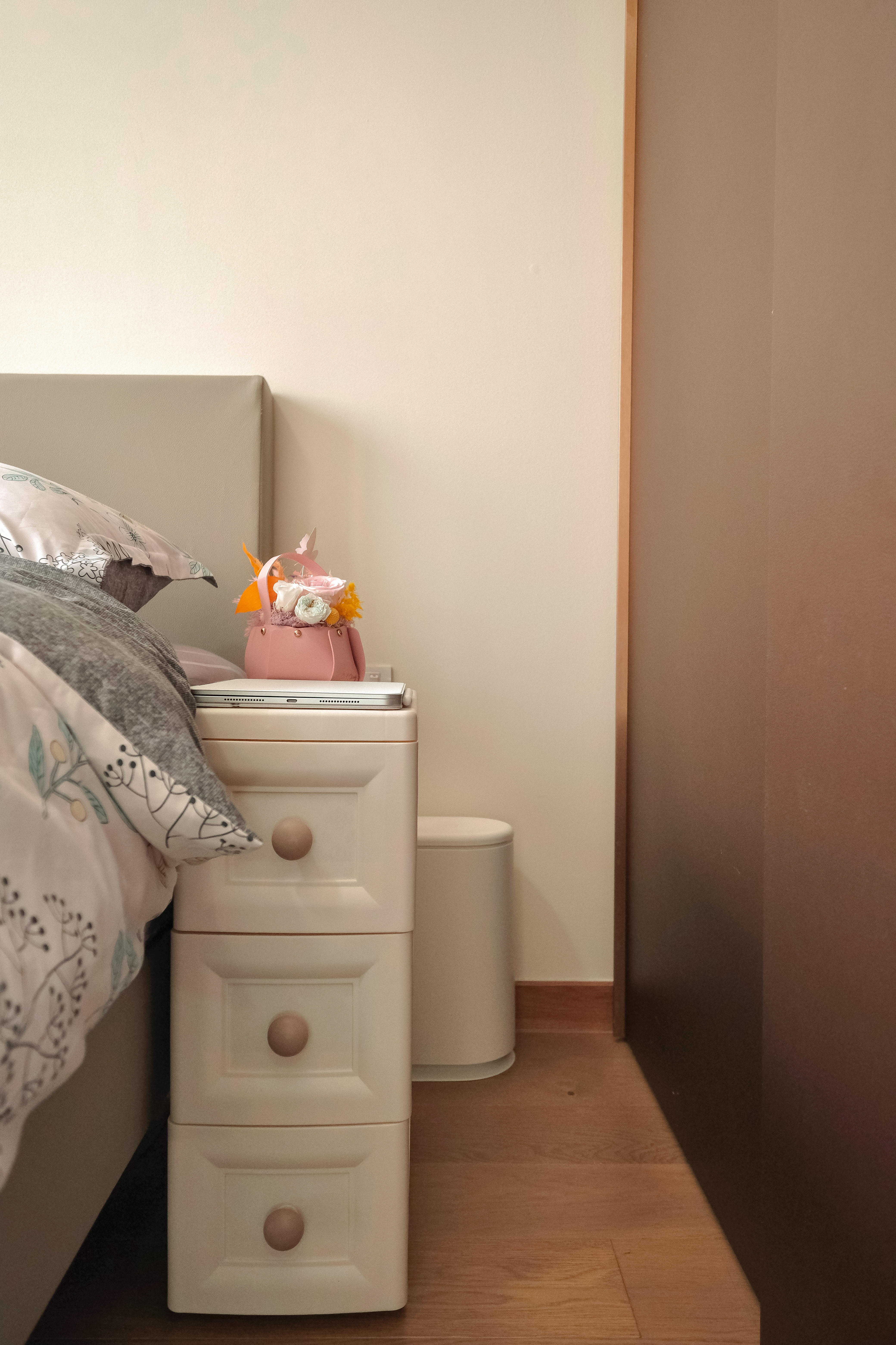 Embrace the simplicity and functionality of the bedroom!  - White bedside table, floral pillow, gray and white patterned