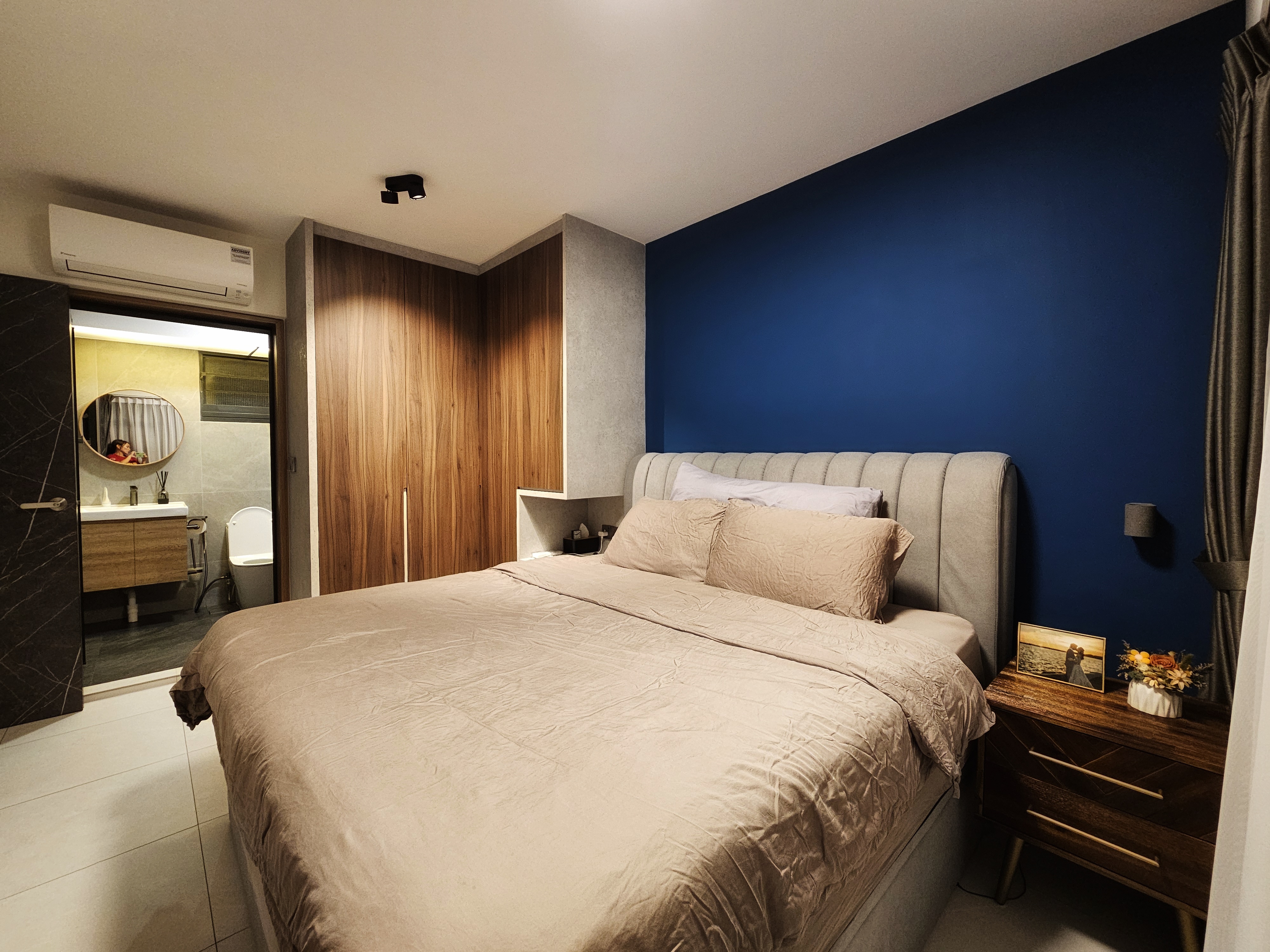 Stepping into elegance and tranquility with our blue feature wall! - Modern bedroom with beige bedding, wooden wardrobe, blue