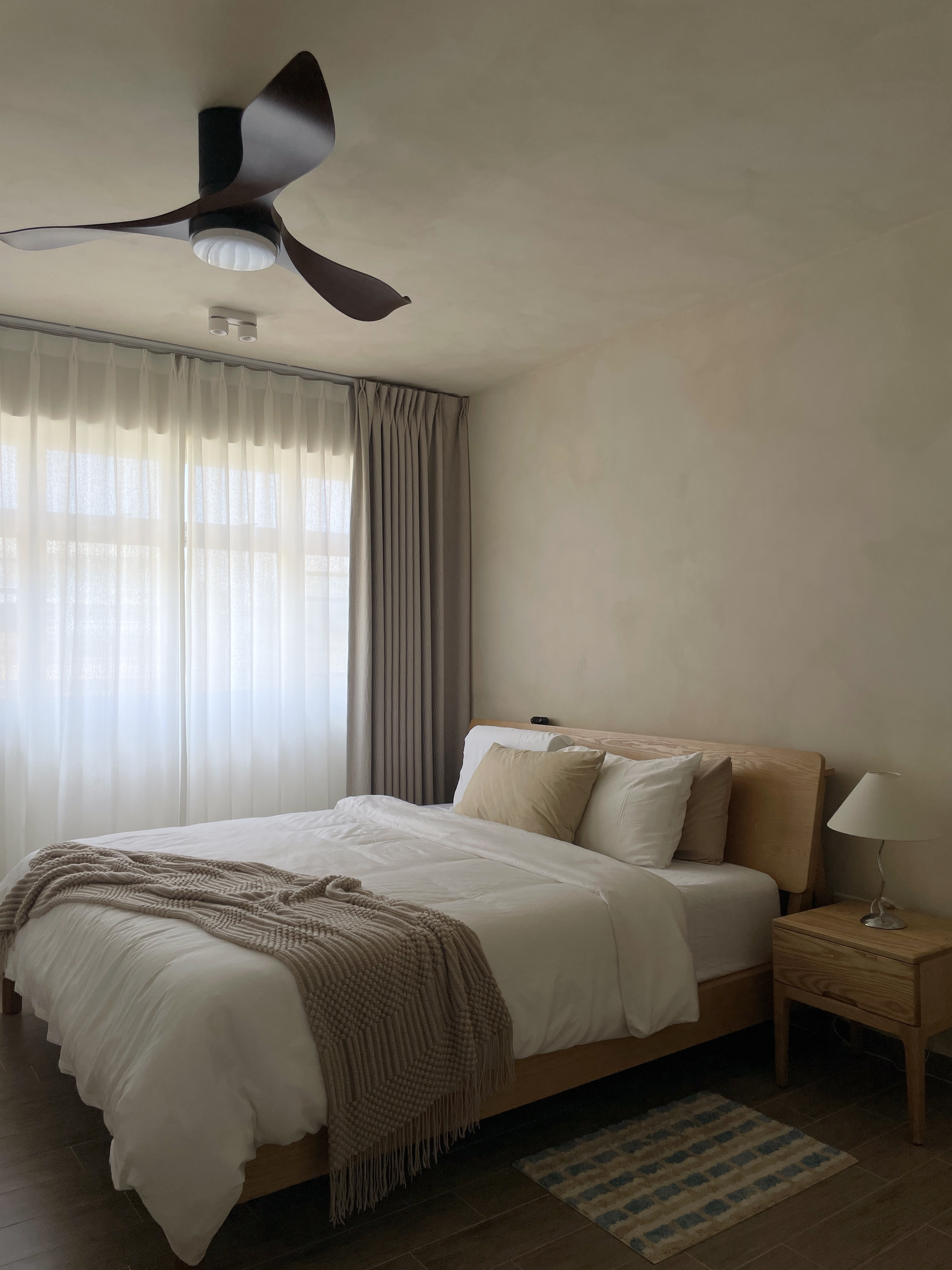 Our Bedroom: It's All About the Mood - White bed with beige and brown throw blanket, wooden headboard, beige and brown