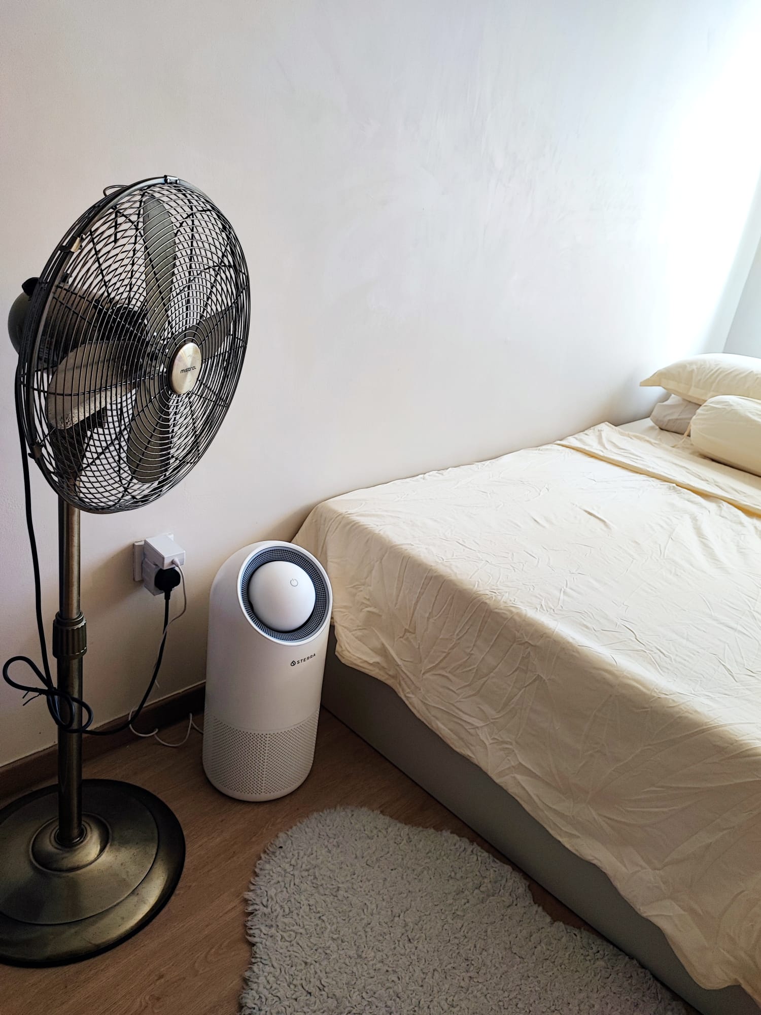 Maximizing flexibility: Minimal cosy bedroom with no built-ins - electric fan, standing fan, white wall, minimalist room