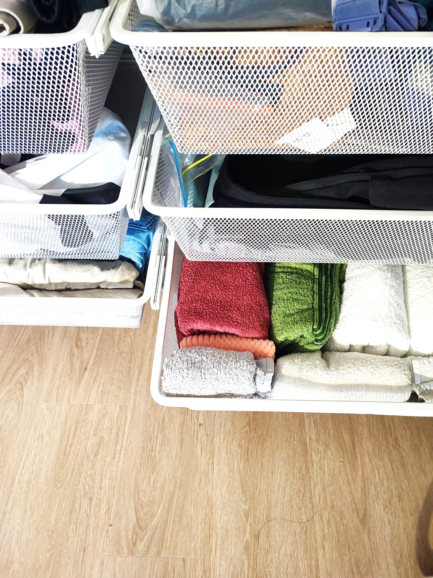 Maximizing flexibility: Minimal cosy bedroom with no built-ins - wire basket, neatly organized, laundry supplies, towels