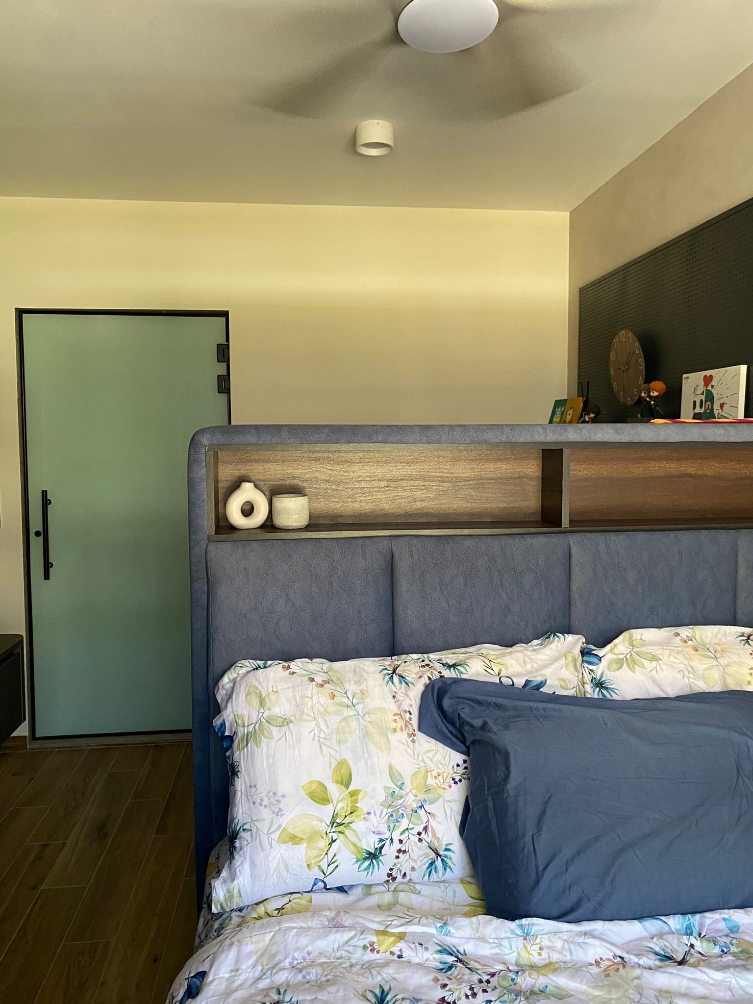 Integrating sleep and play for a space constrained 4-room BTO - Floral-patterned bedspread, blue pillows, wooden headboard