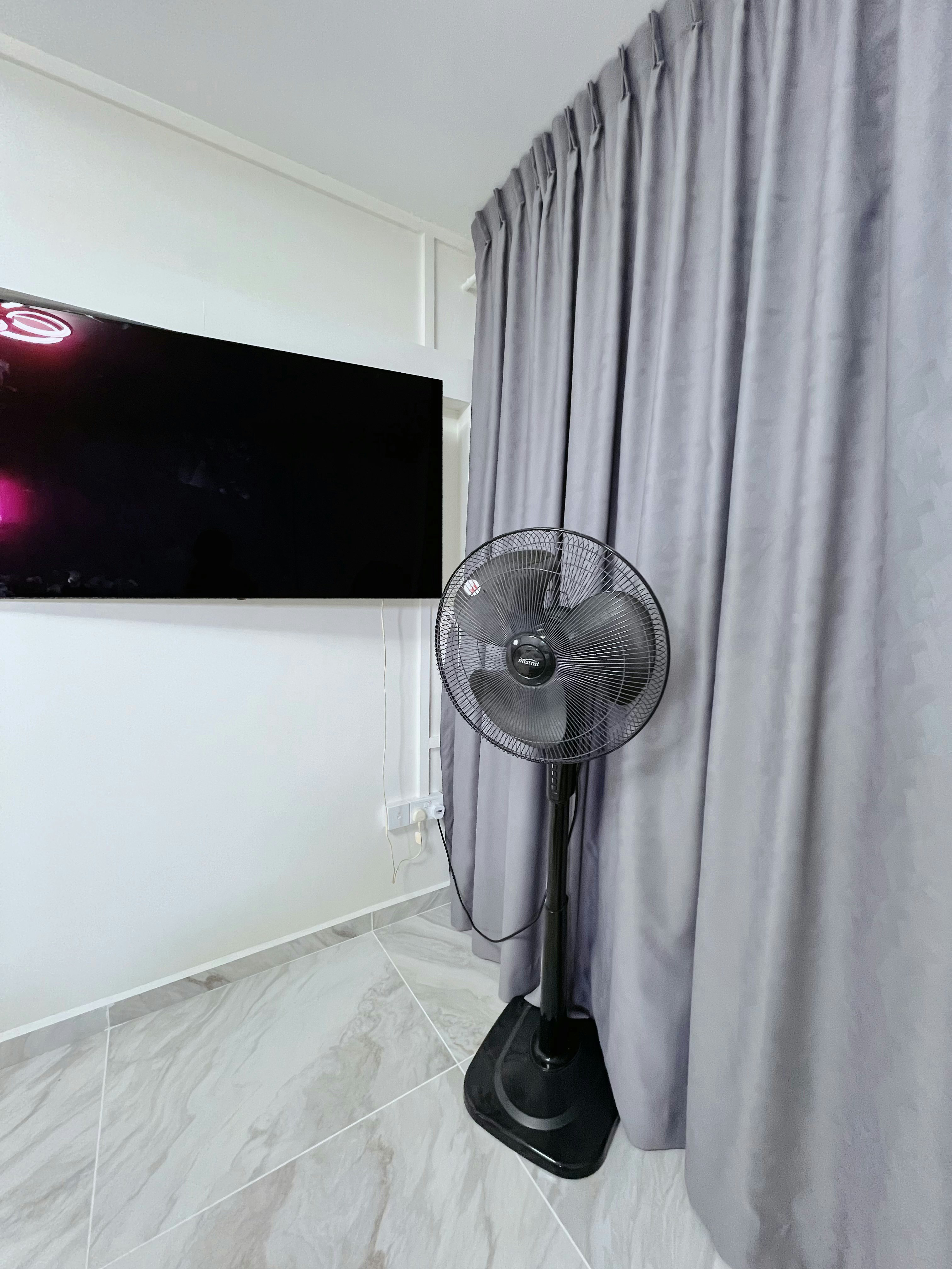 The Master Bedroom: Peaceful nights and bright mornings start here!  - Black flat-screen TV, gray curtains, black standing